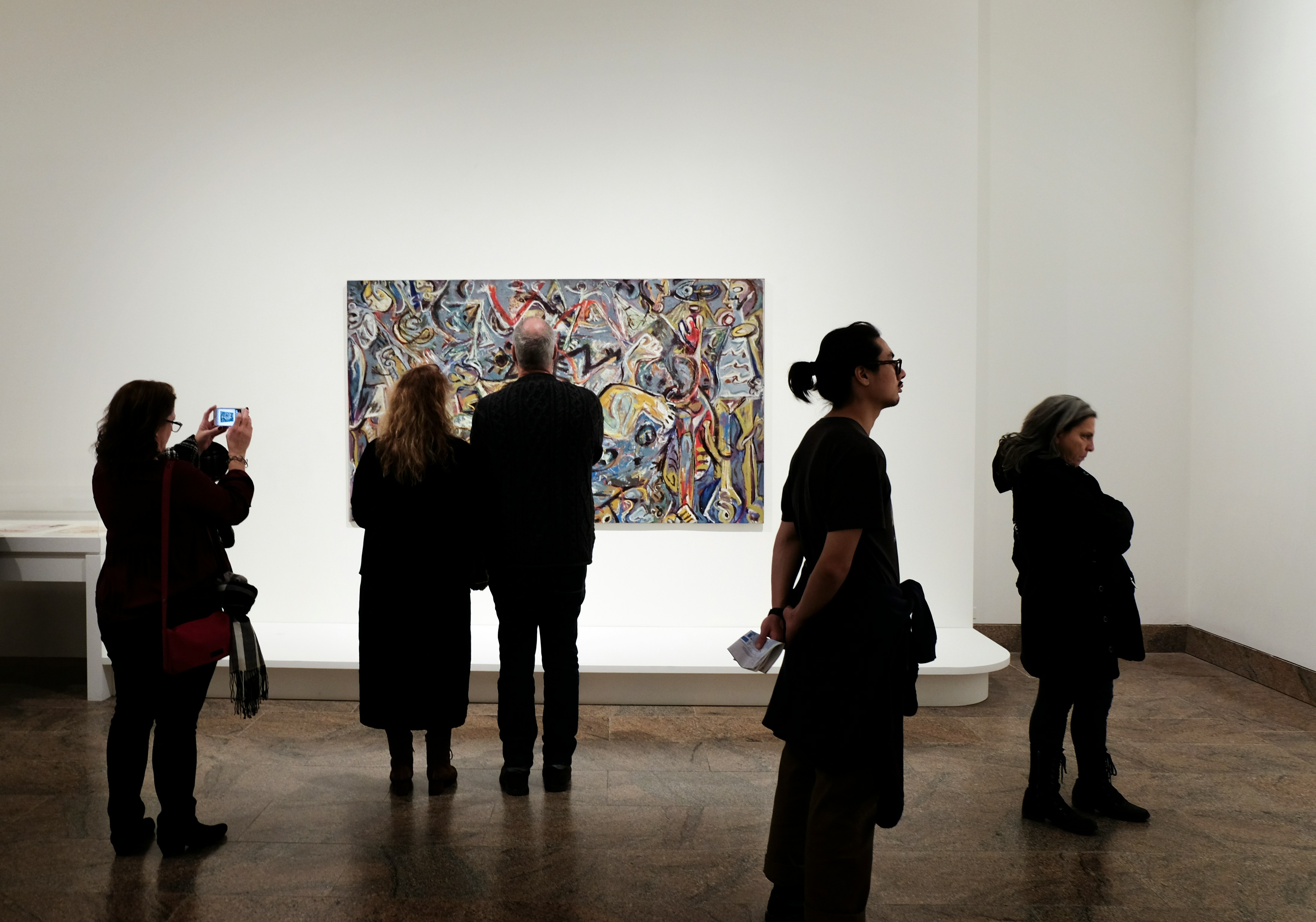 Photo by Unsplash An illustrative photo of a group of people standing in front of a painting.