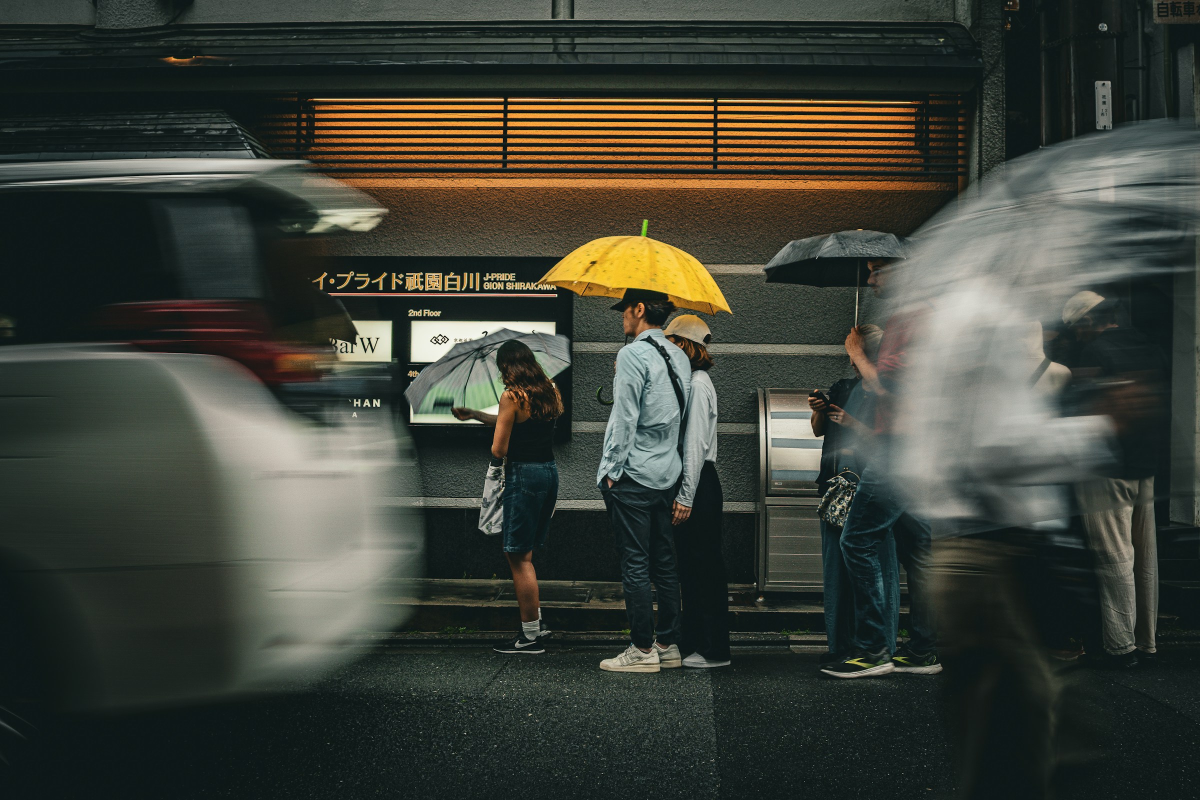 An illustrative photo of people stand under umbrellas.