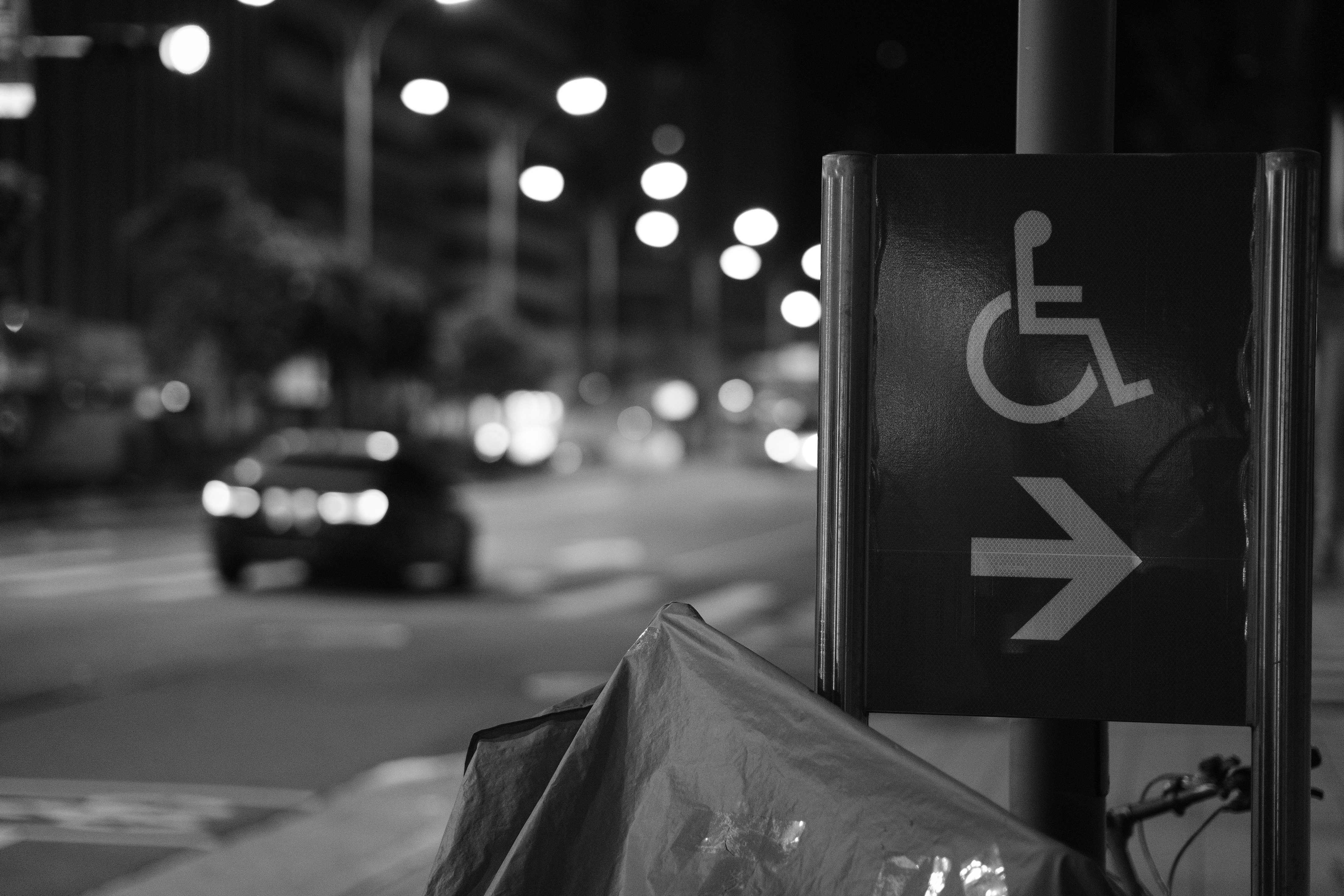An illustrative photo of a handicapped parking sign on a city street.