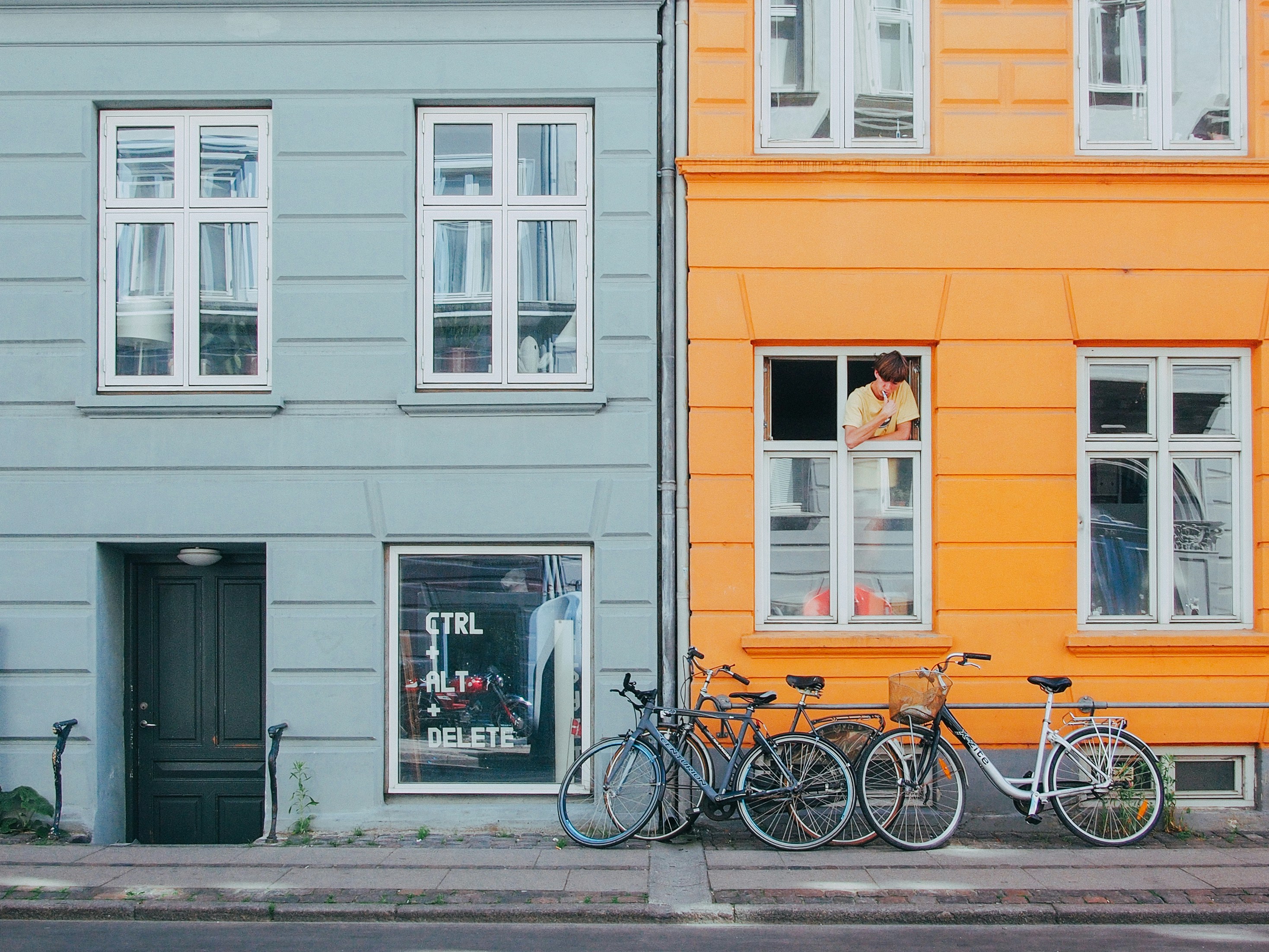 An illustrative photo of a person looking at bicycles from a window.