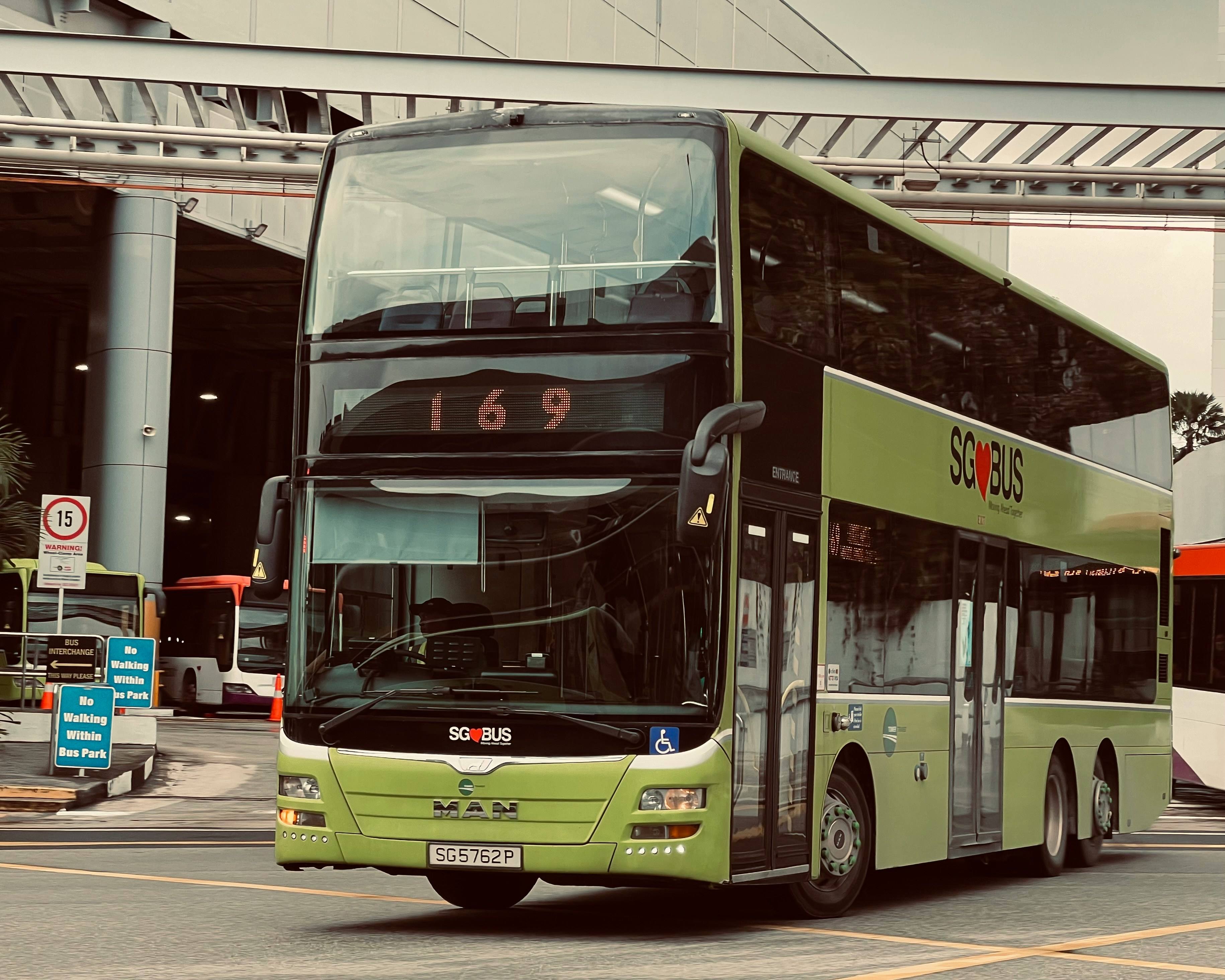 An illustrative photo of a green double decker bus driving down a street.