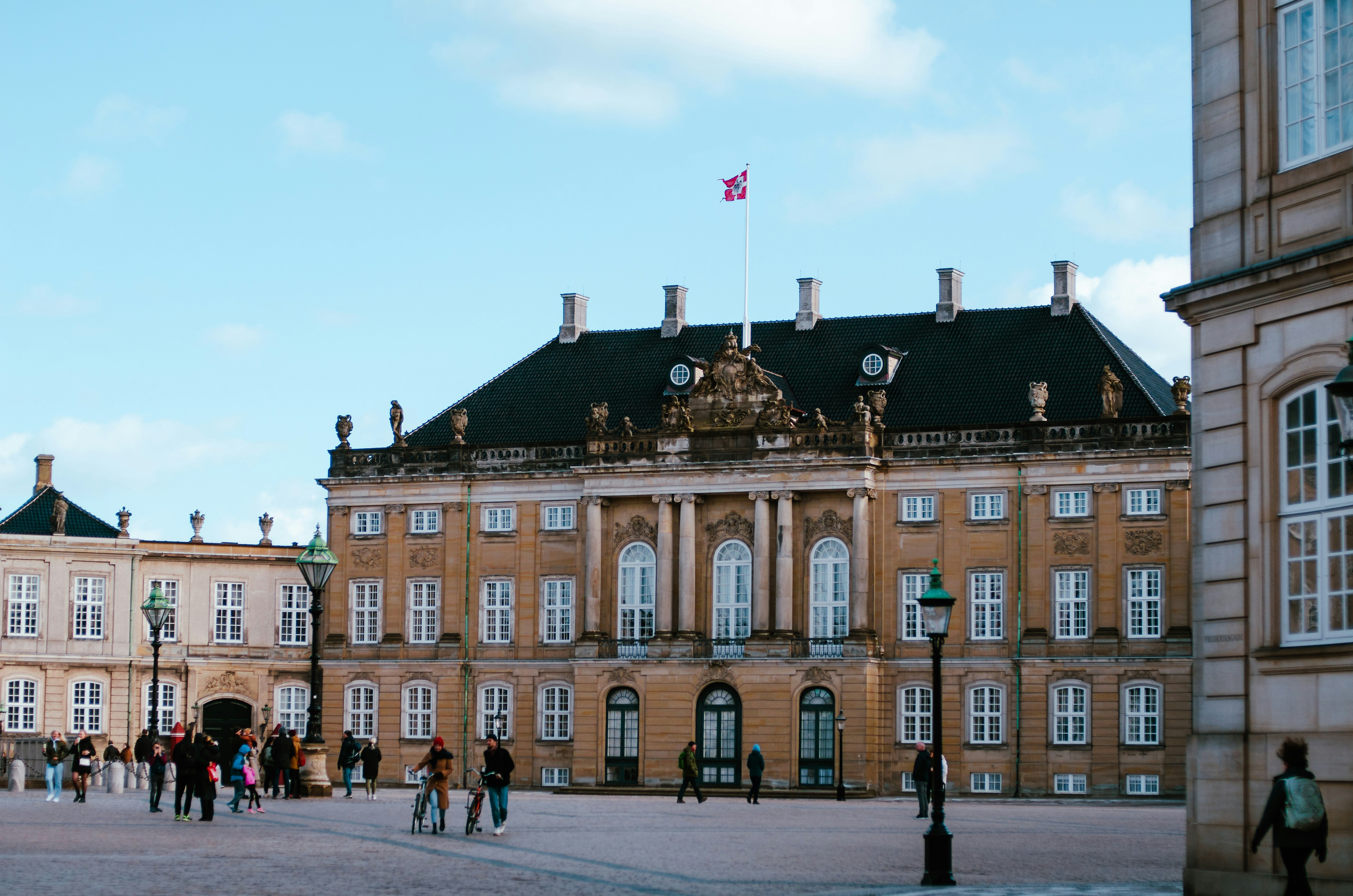 Photo by Unsplash An illustrative photo of a group of people walking around a large building.
