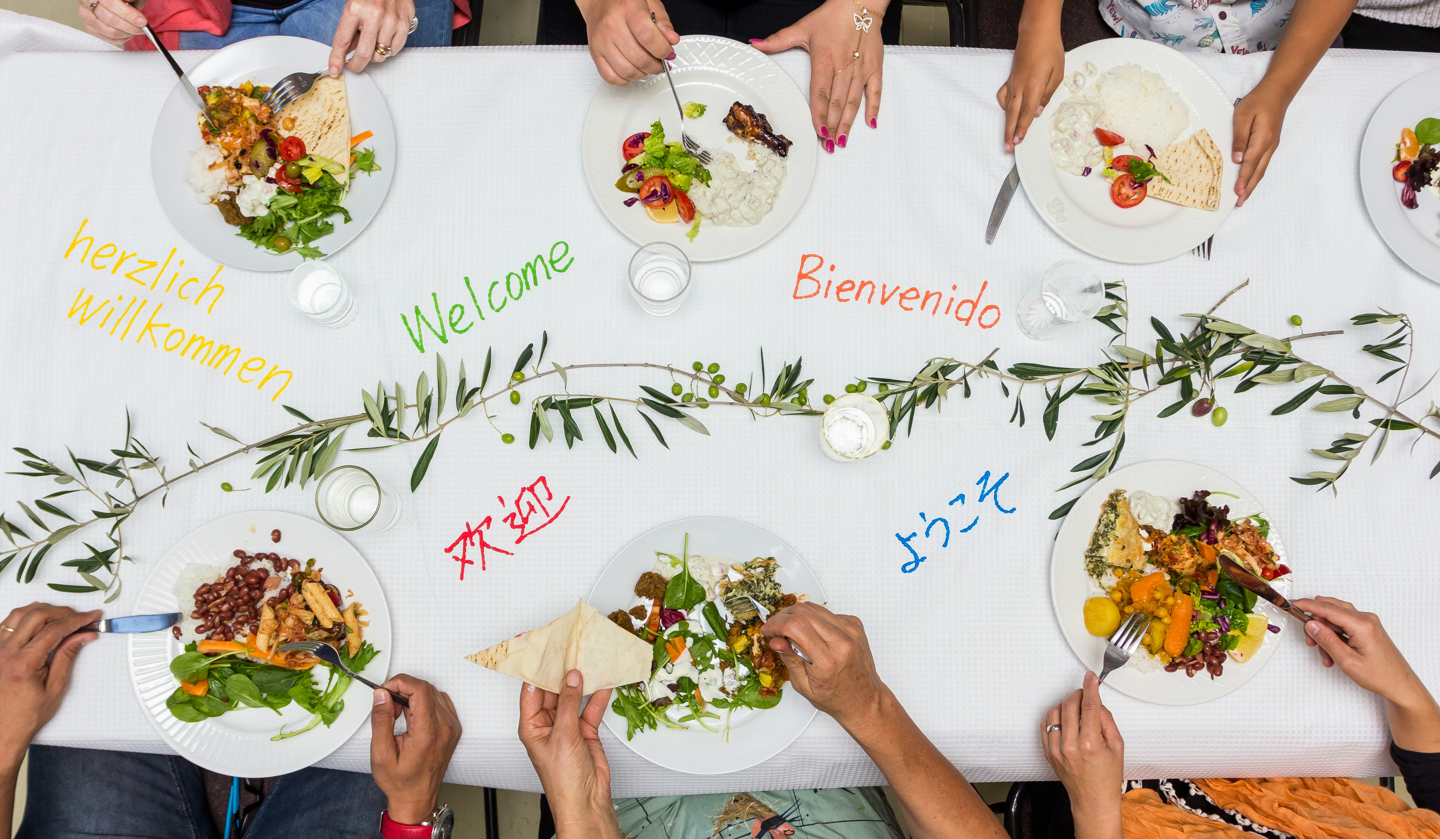 An illustrative photo of a group of people sitting around a table eating food.