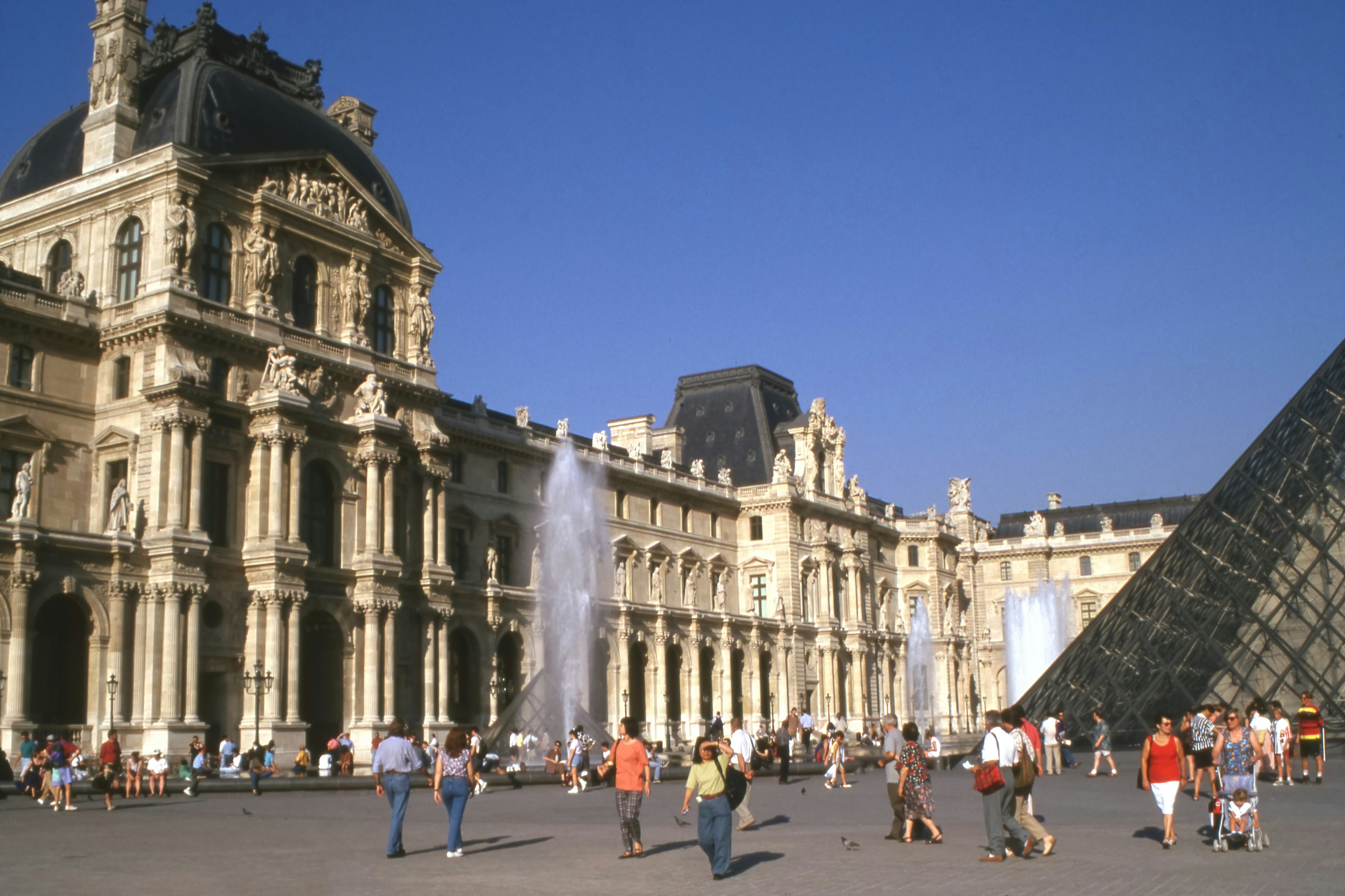 An illustrative photo of a group of people standing in front of a large building.