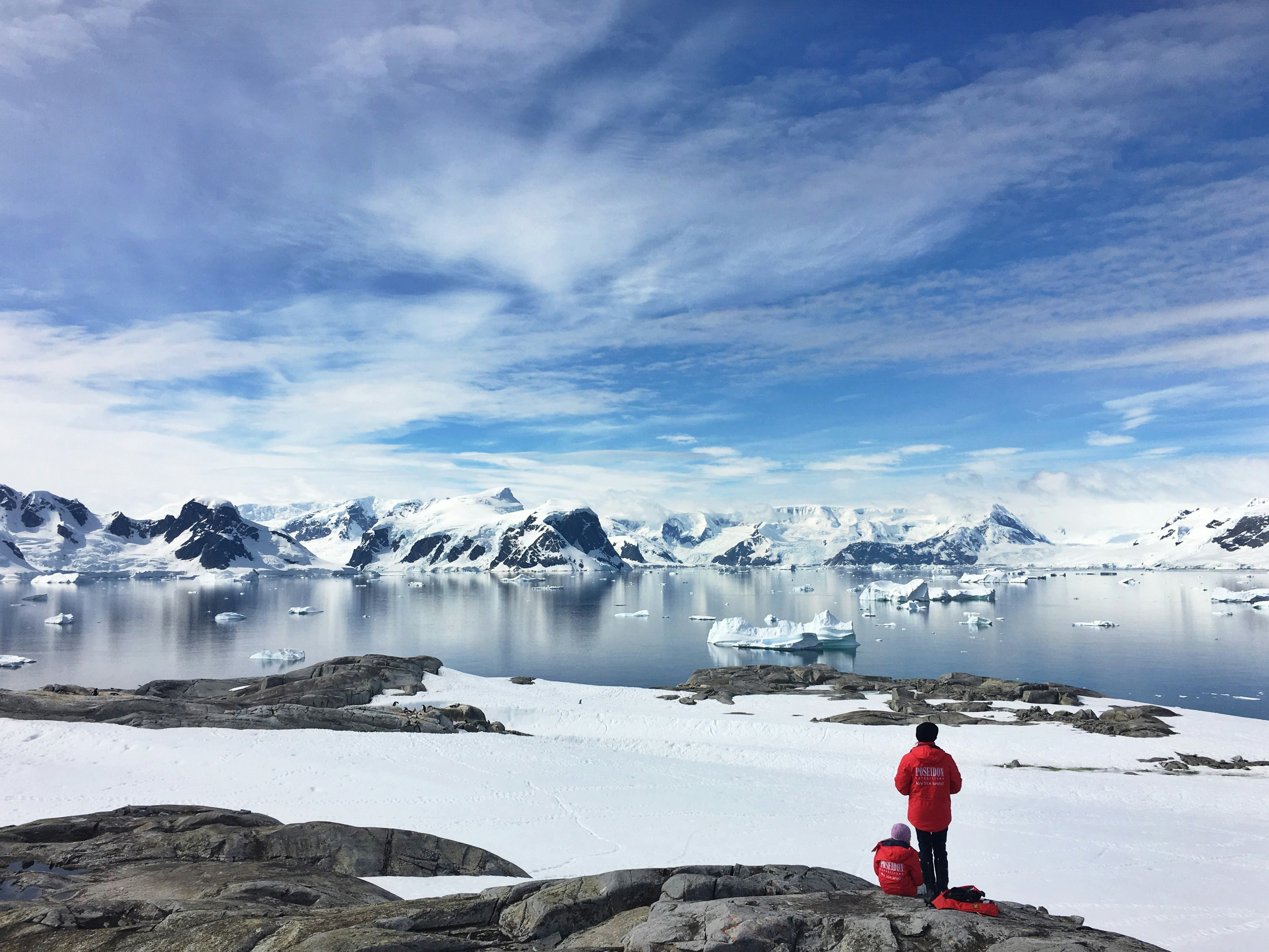 An illustrative photo of two people standing on a snow-covered coast.