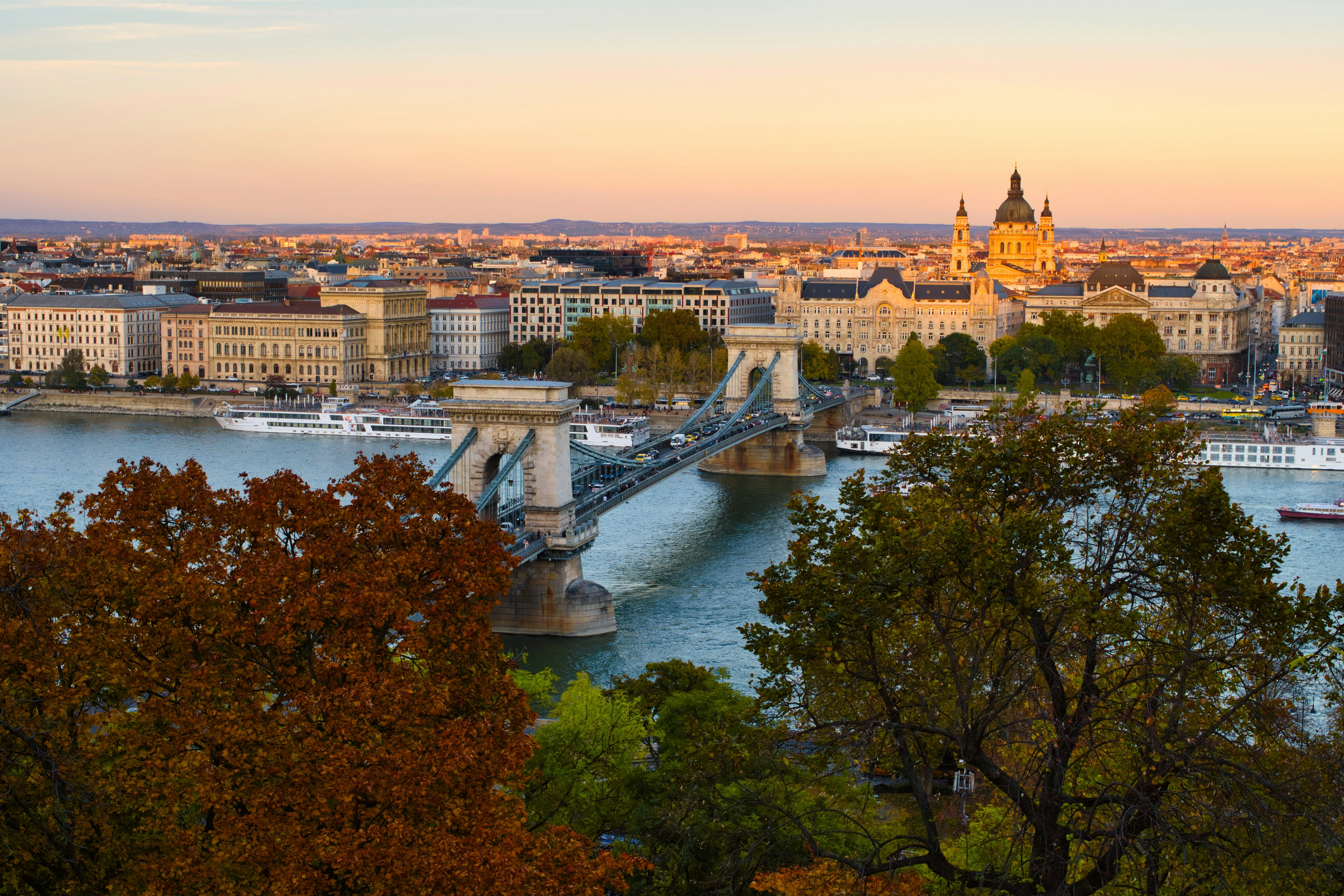 An illustrative photo of a bridge over a river near a city.