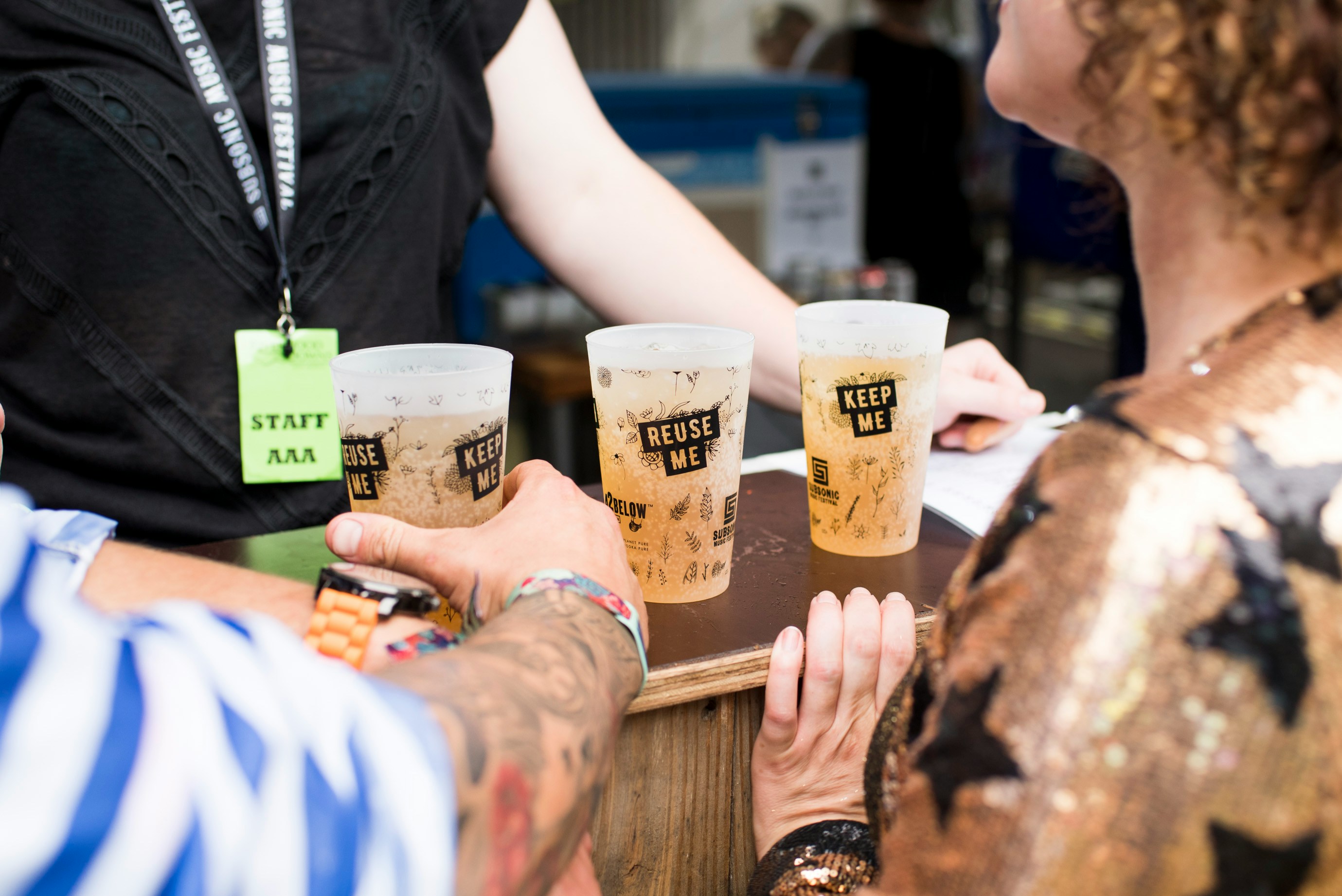 Photo by Unsplash An illustrative photo of three filled Reuse Me cups on brown table.