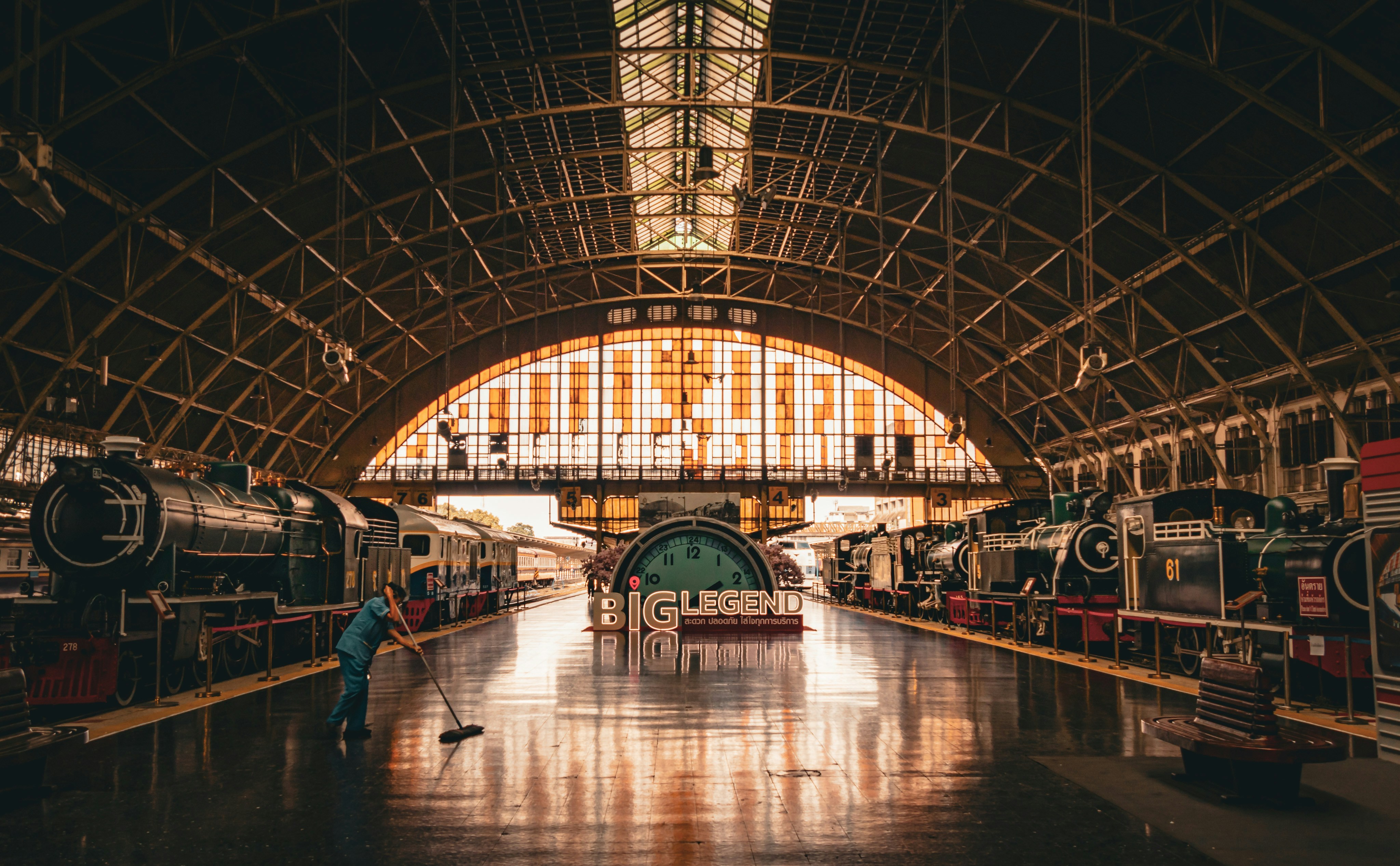 An illustrative photo of a train station with a man sweeping the floor.
