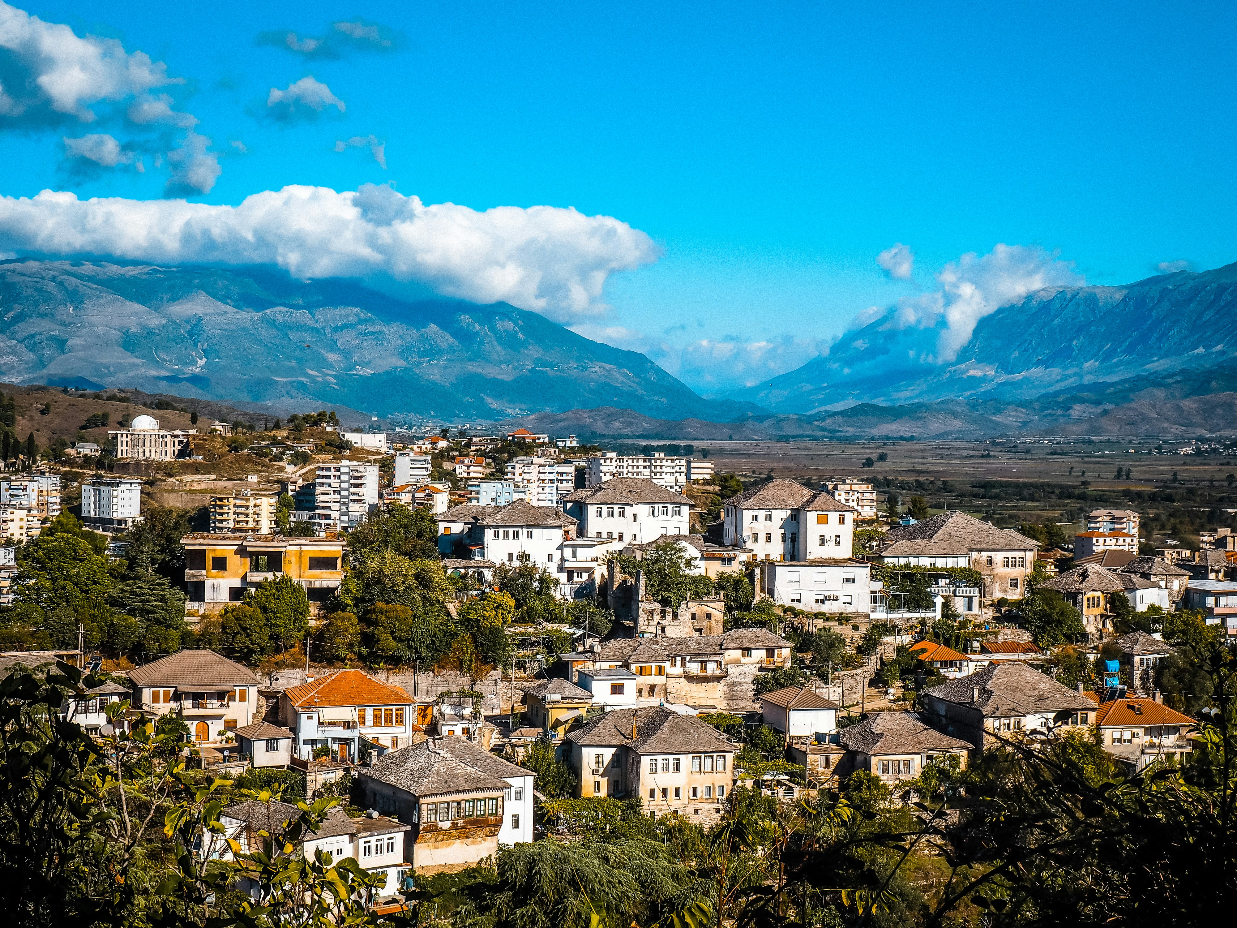 An illustrative photo of a view of a city with mountains in the background.