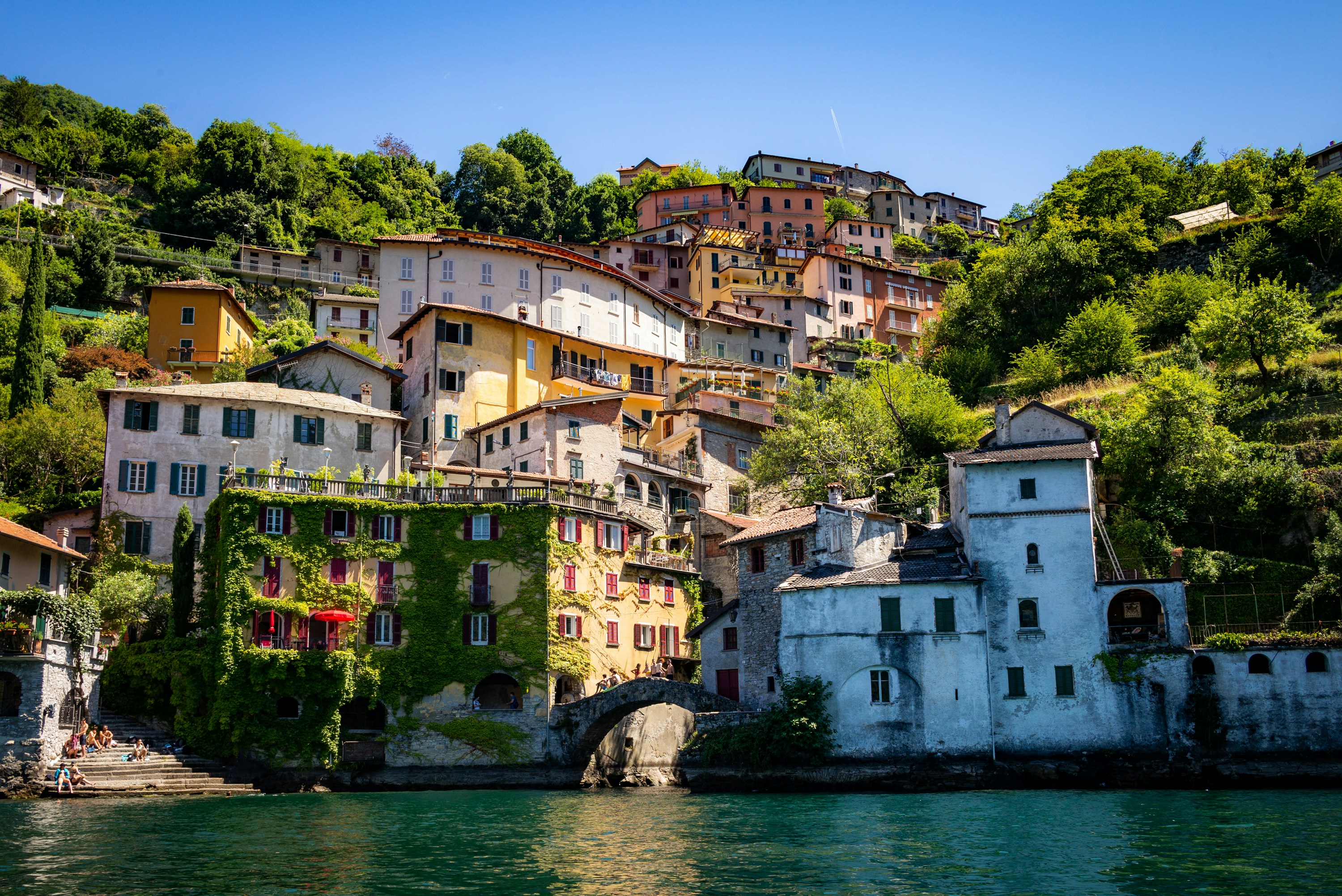 Photo by Unsplash An illustrative photo of houses on a hill near a lake.