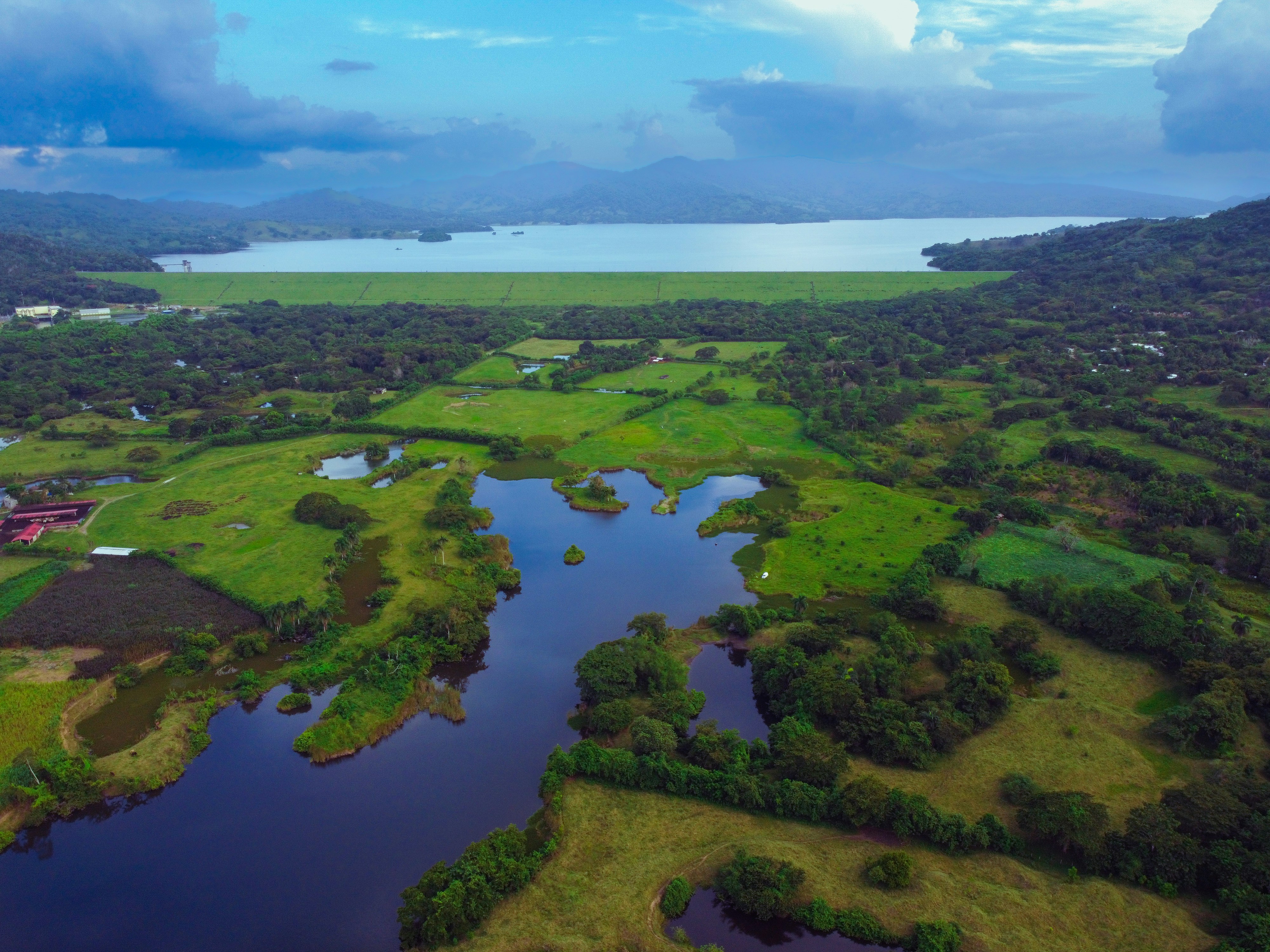 An illustrative photo of a large body of water surrounded by lush green fields.