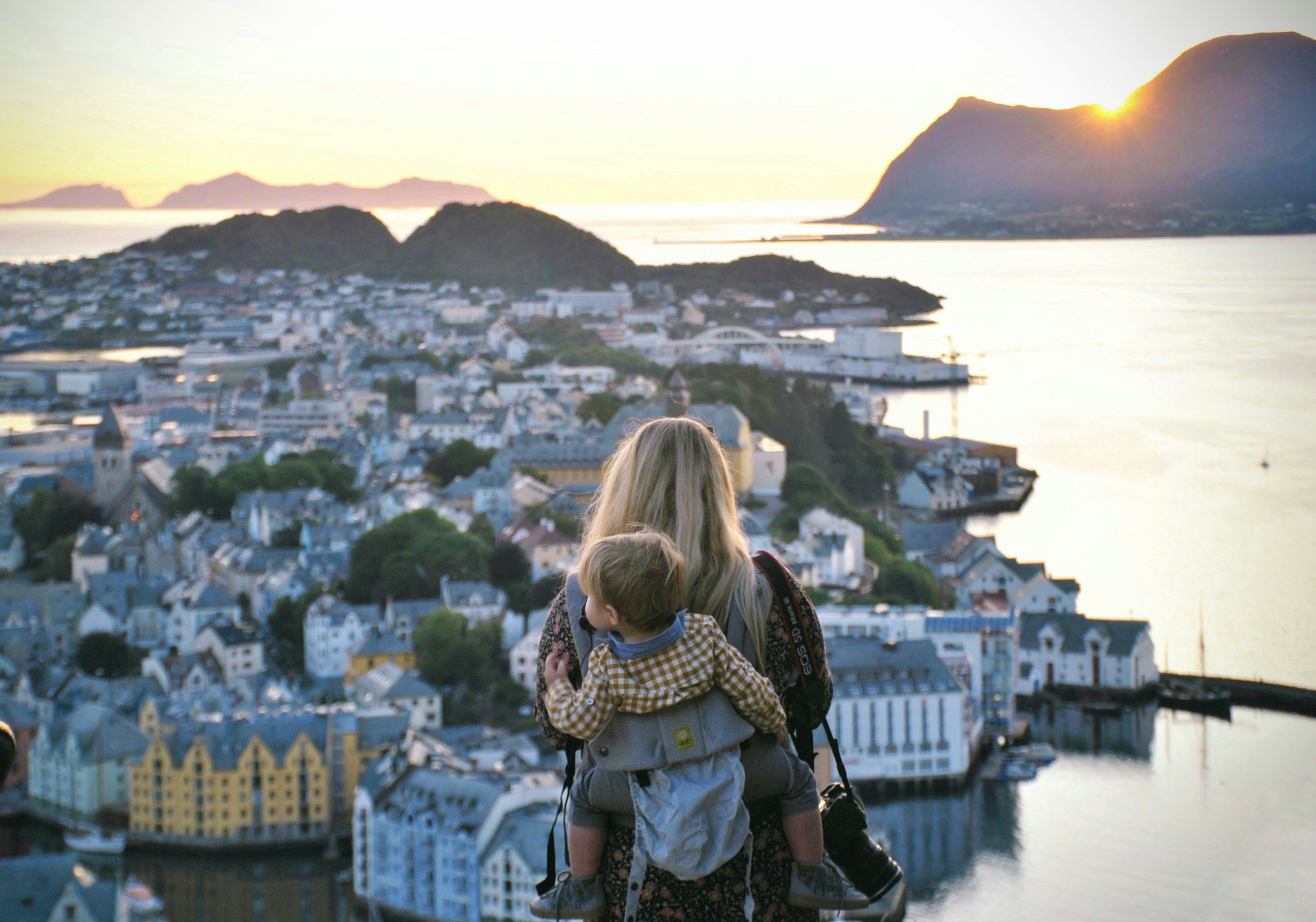 A woman with a baby overlooking a city over a bay