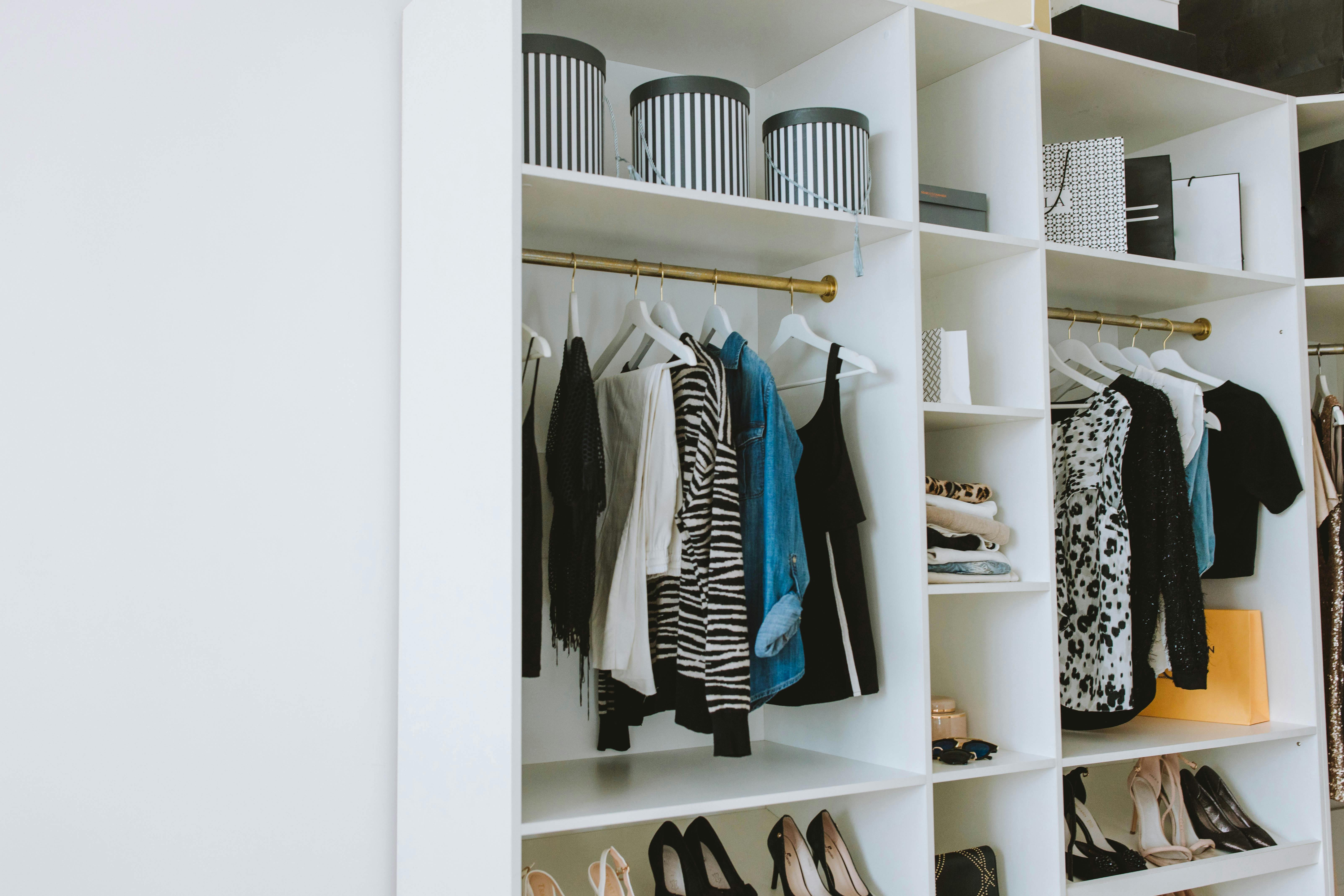 Clothes hanged on white wooden cabinet.