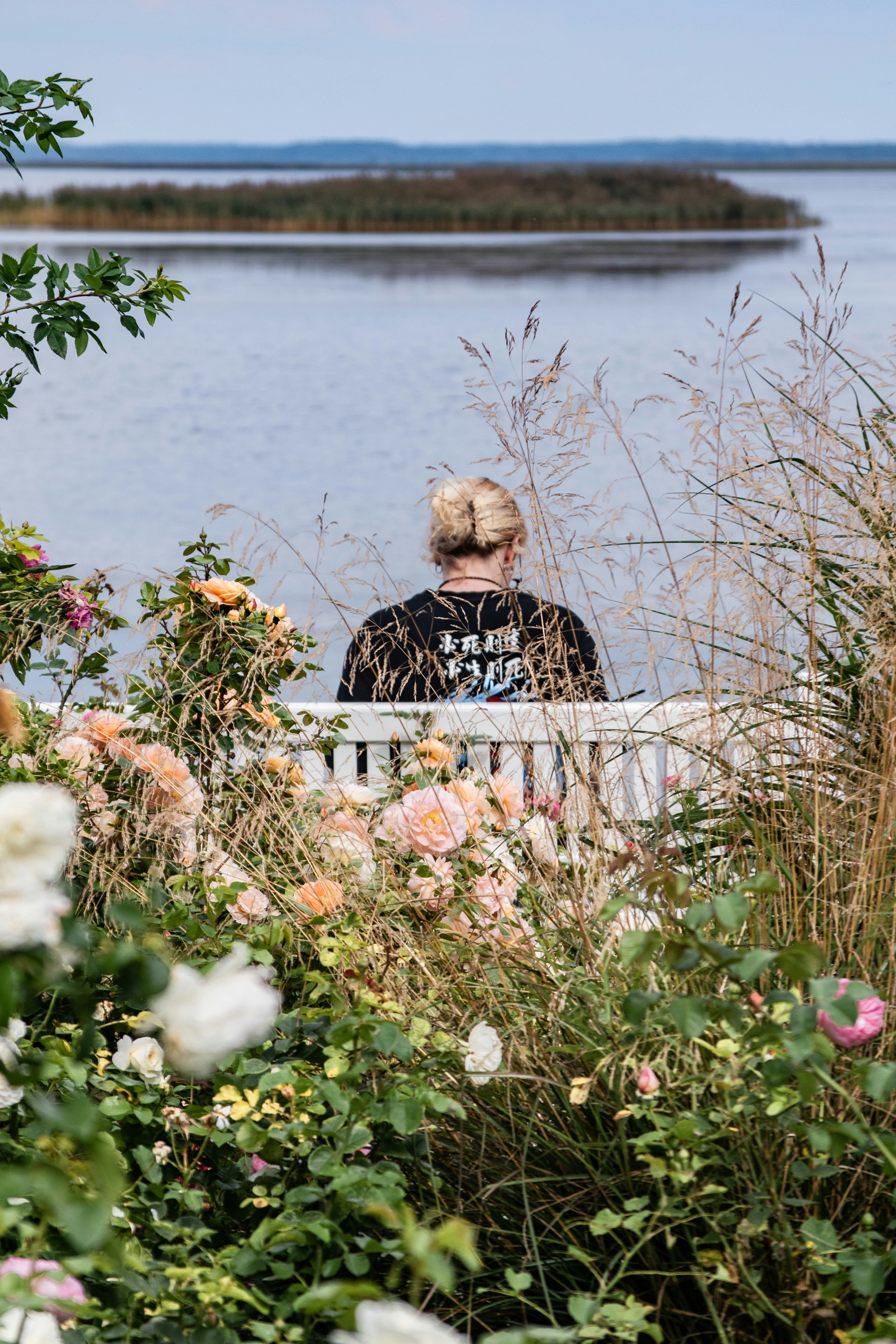 Person on a bench surrounded by greenery