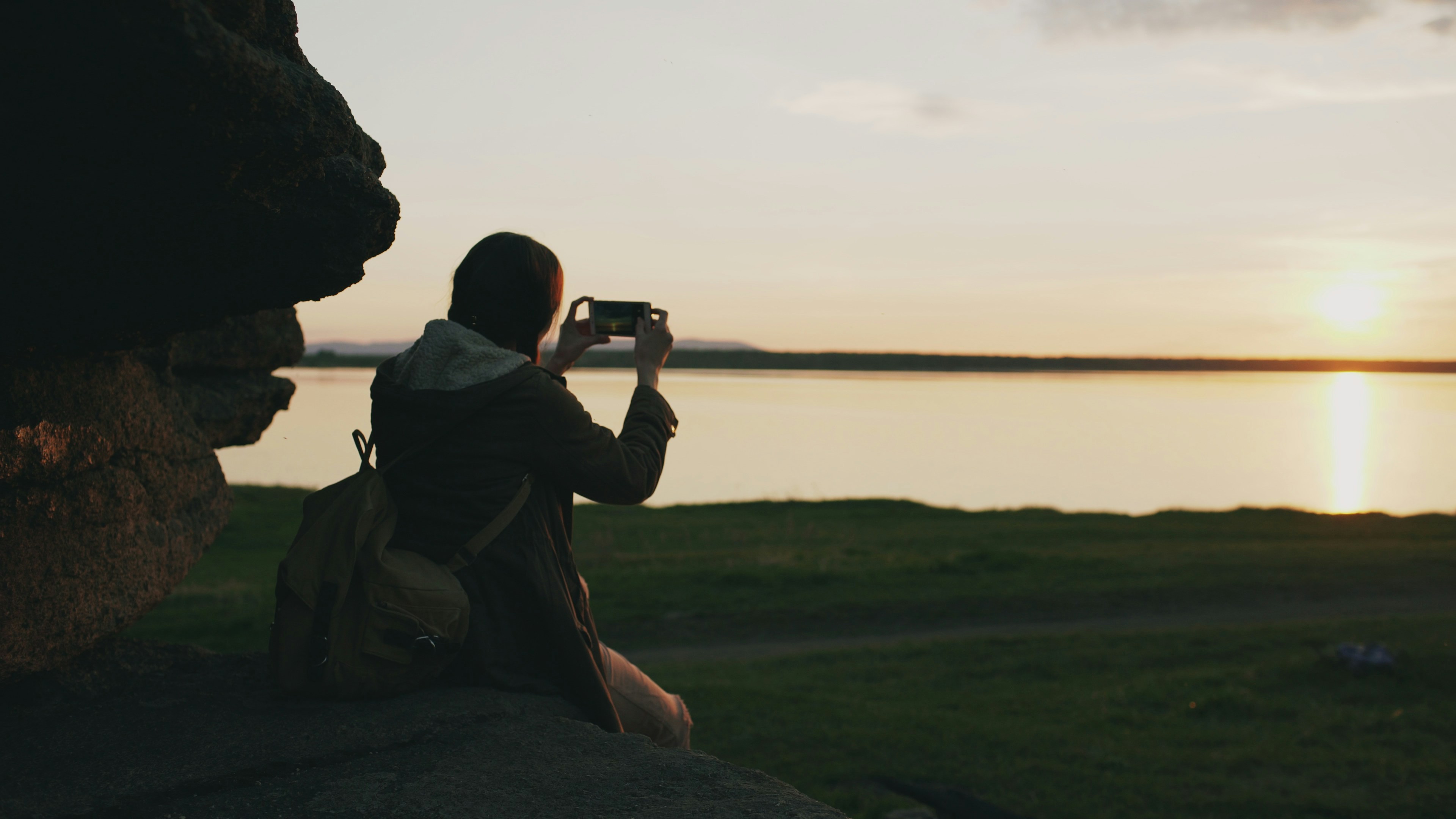 A person taking a photo of a lake