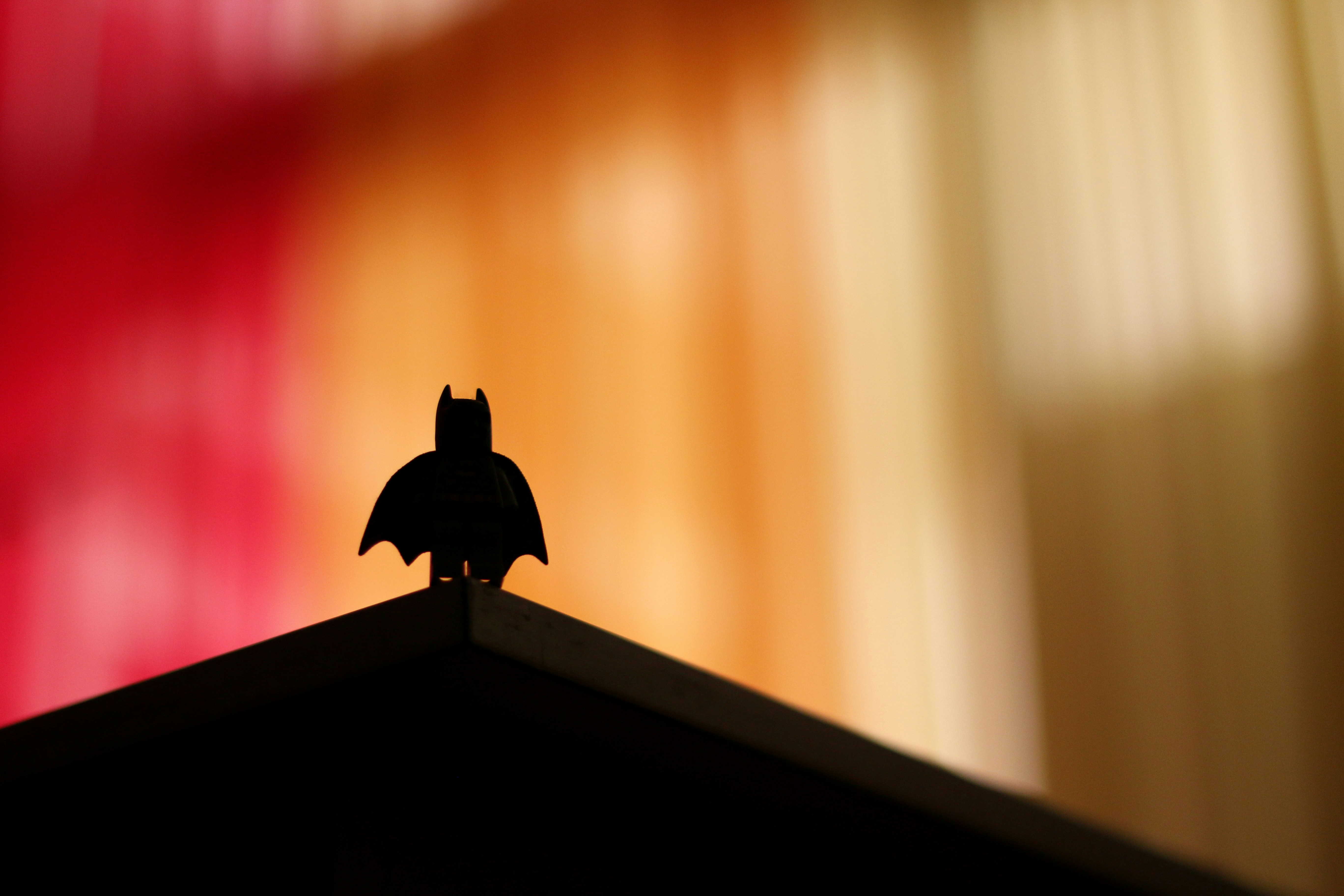Image of a toy superhero silhouette against an orange and red background
