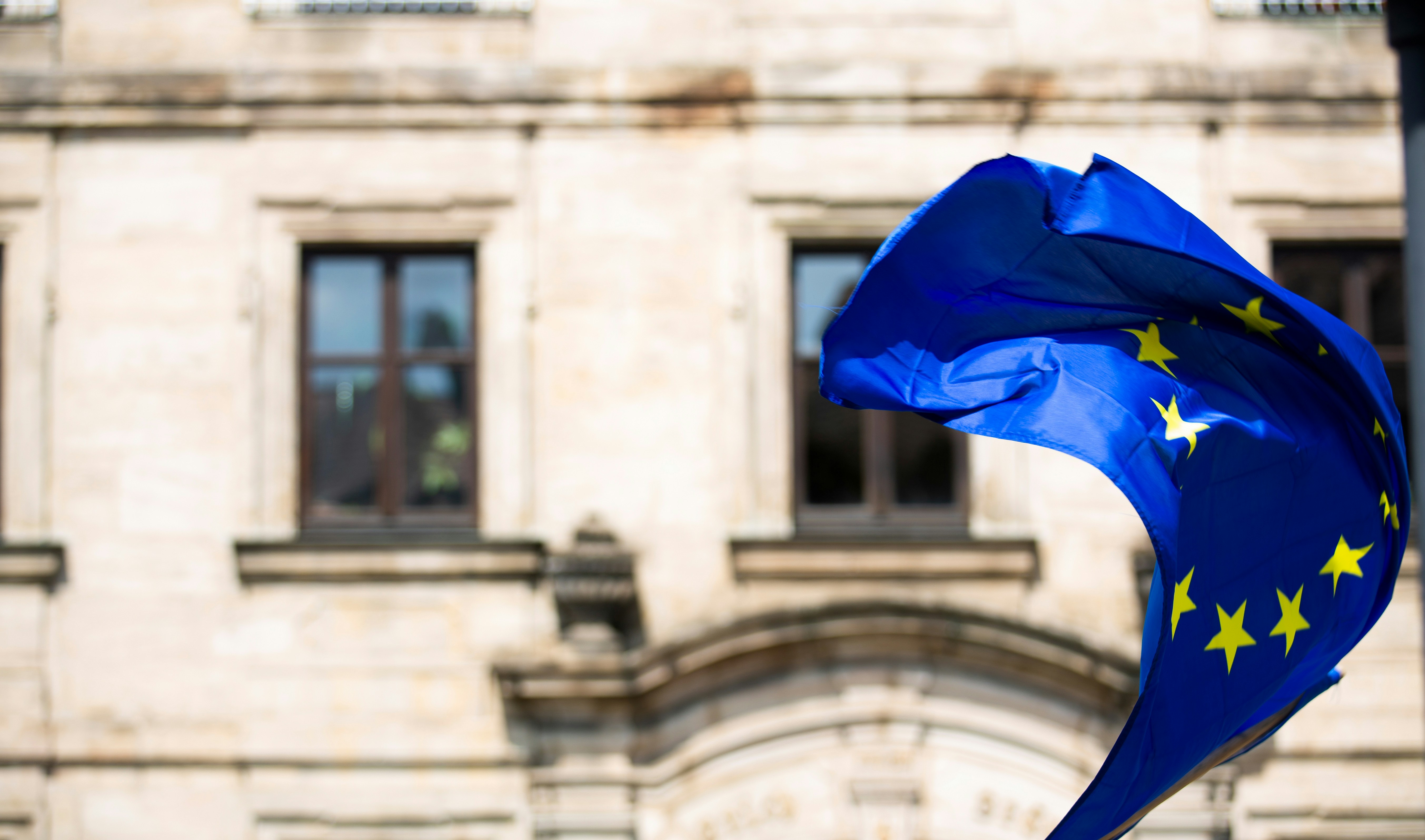 EU flag with a stone building in the background