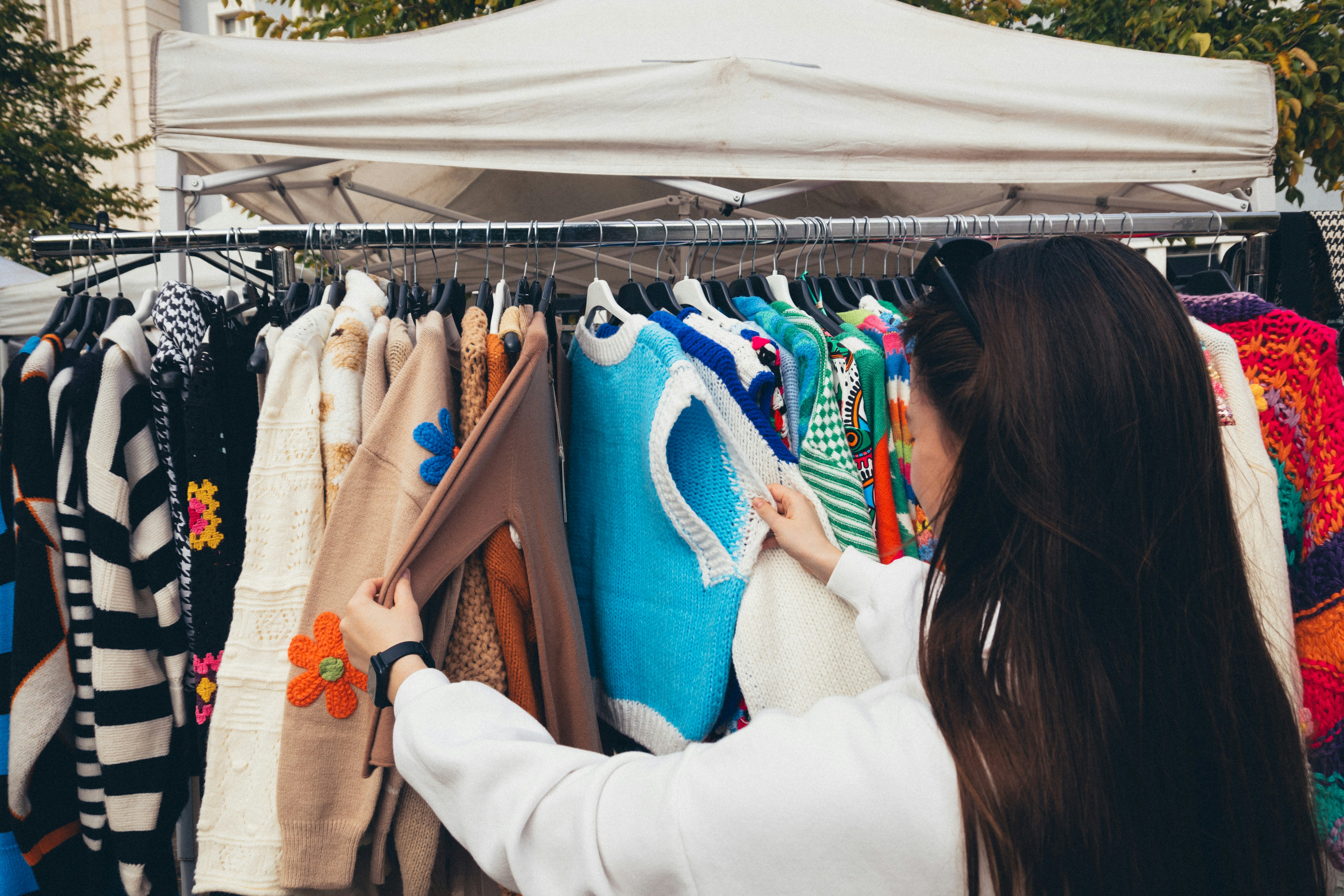 Woman browsing an outdoor clothing market