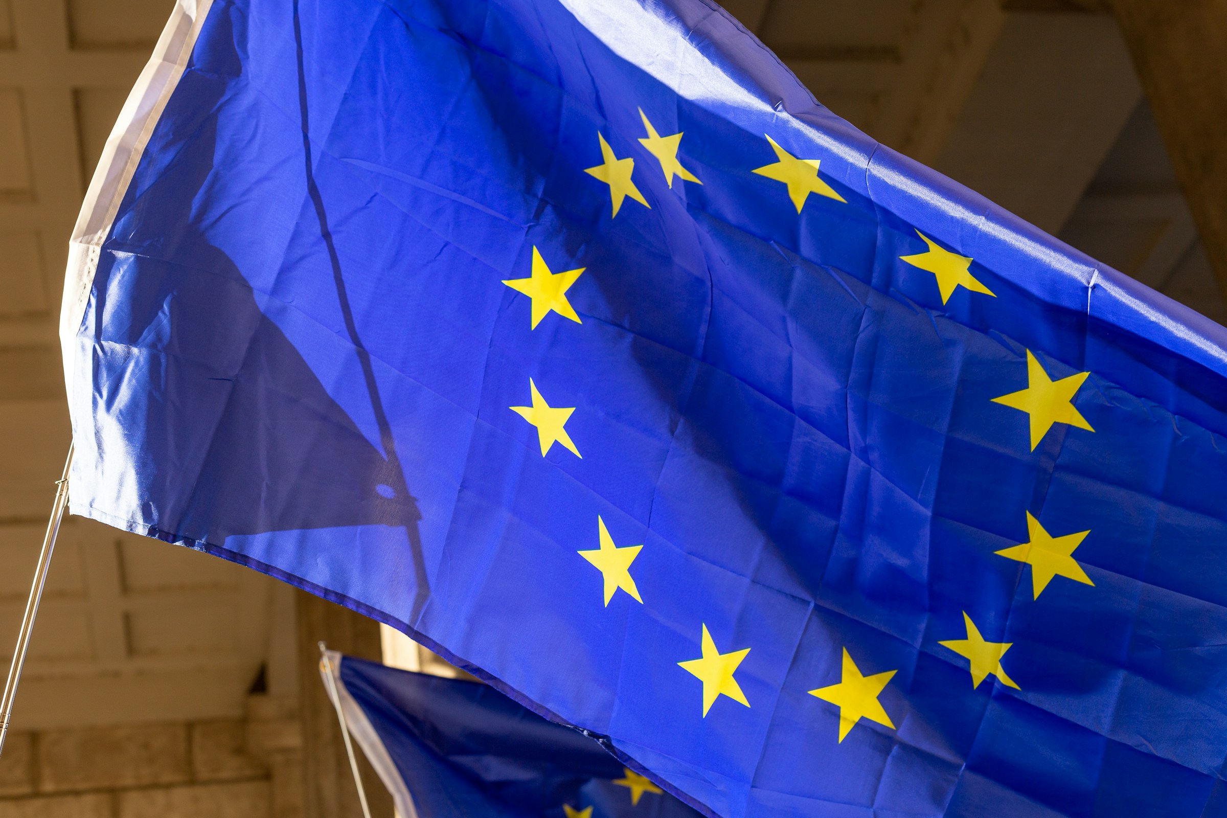 European Union flag displayed indoors, its blue fabric and yellow stars clearly visible.