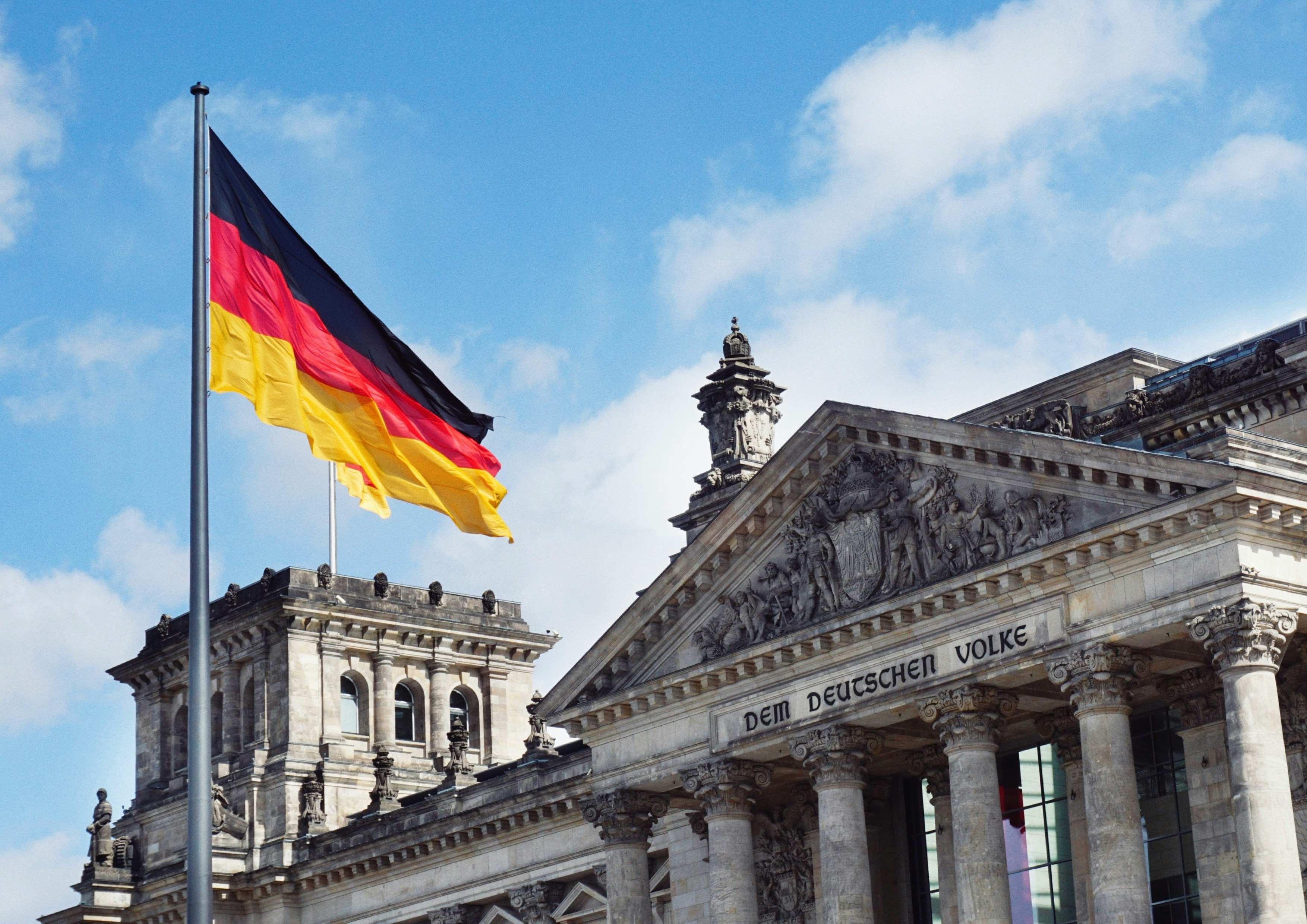 White concrete building with german flag on top