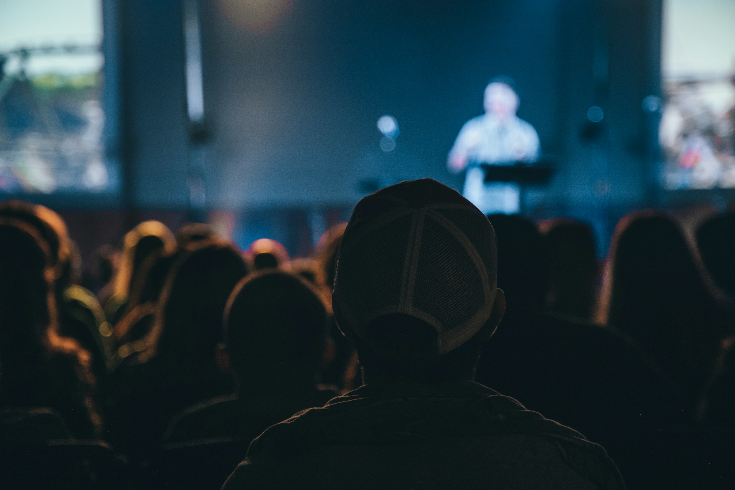 Backshot of a man looking at the stage during night time.  