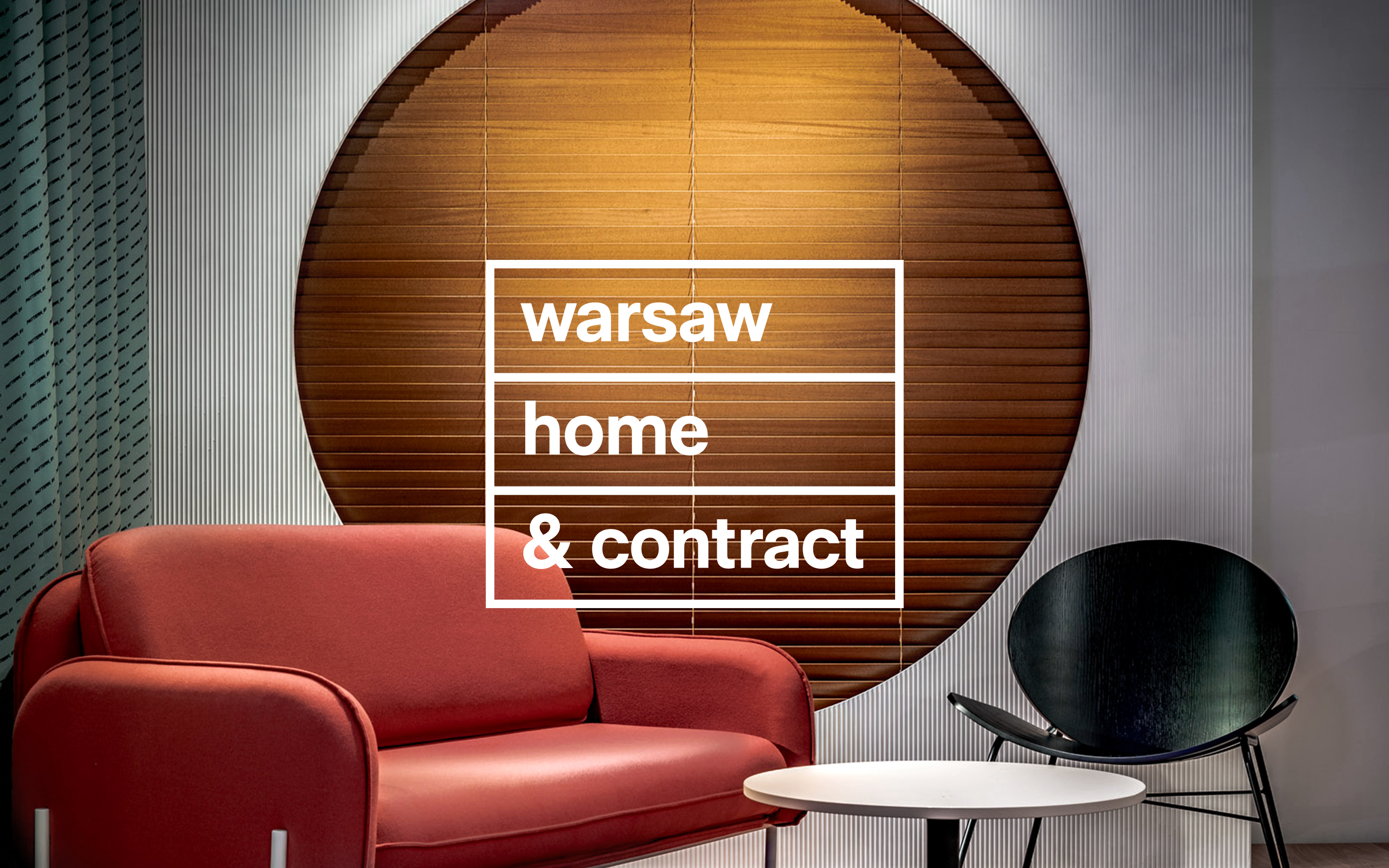 Interior scene with modern furniture and the text “Warsaw Home & Contract” displayed on a circular backdrop.