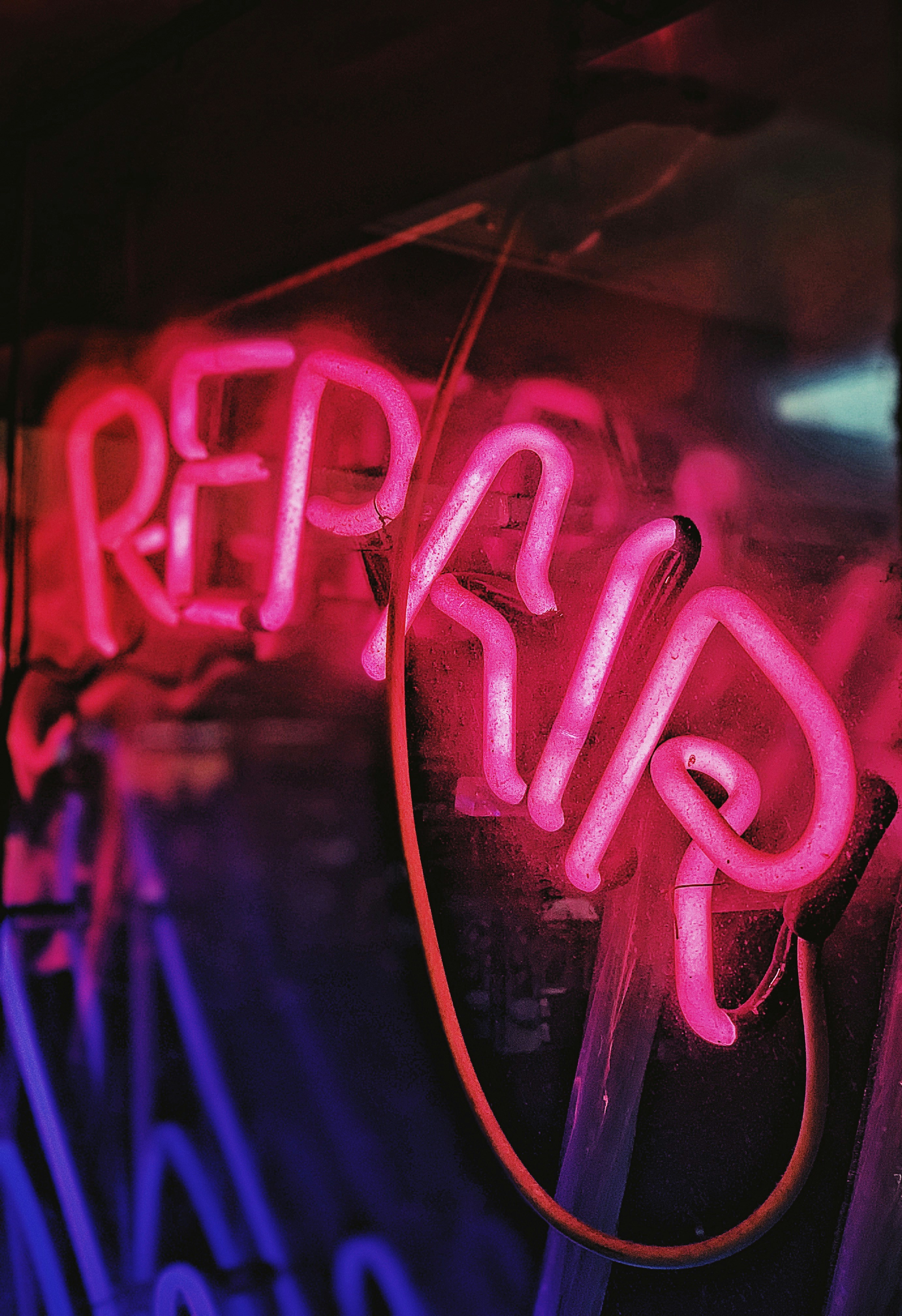Colour photograph of a neon sign with written "repair", Photograph by Jon Tyson on unsplash.org