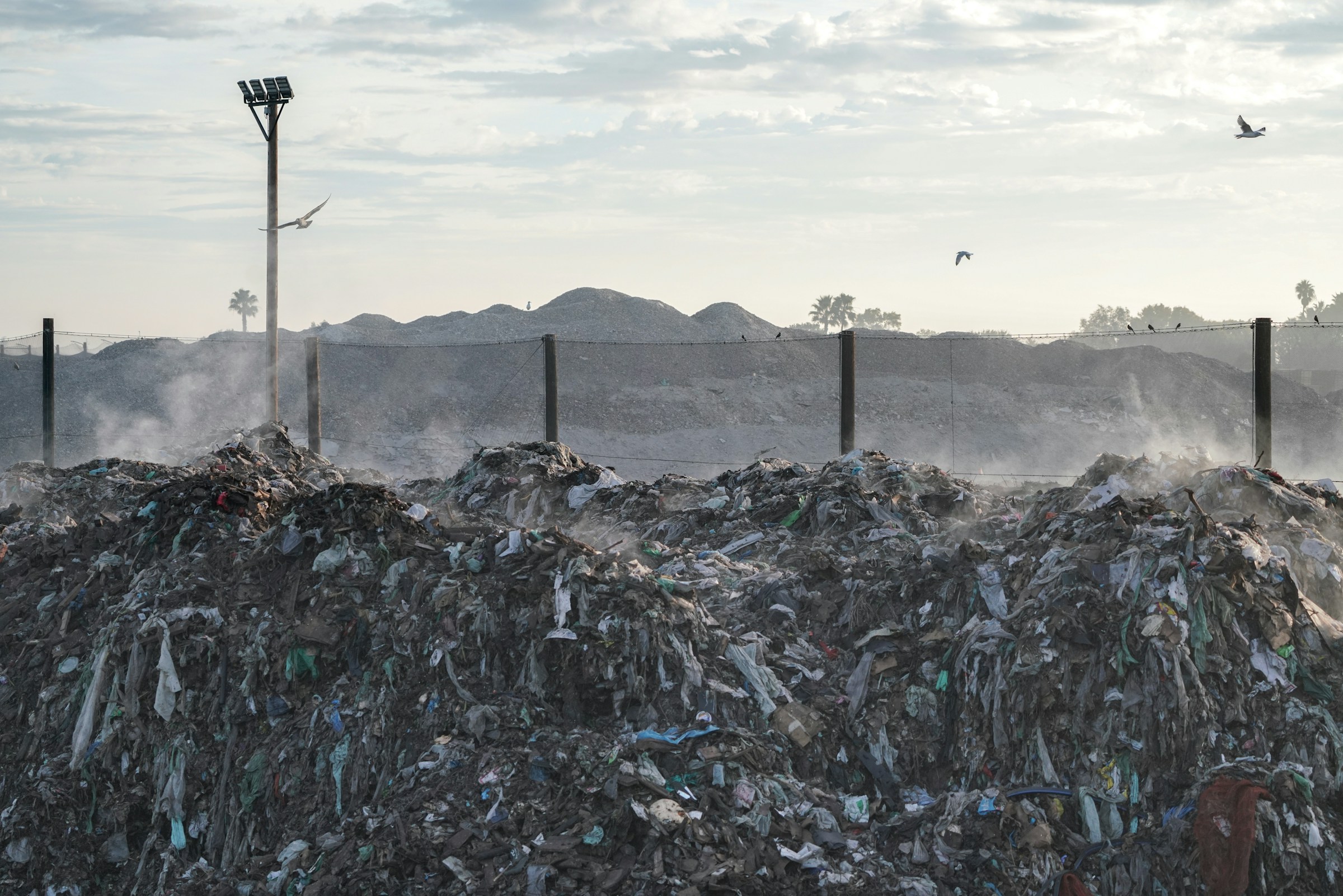 A pile of garbage sitting next to a street light photo