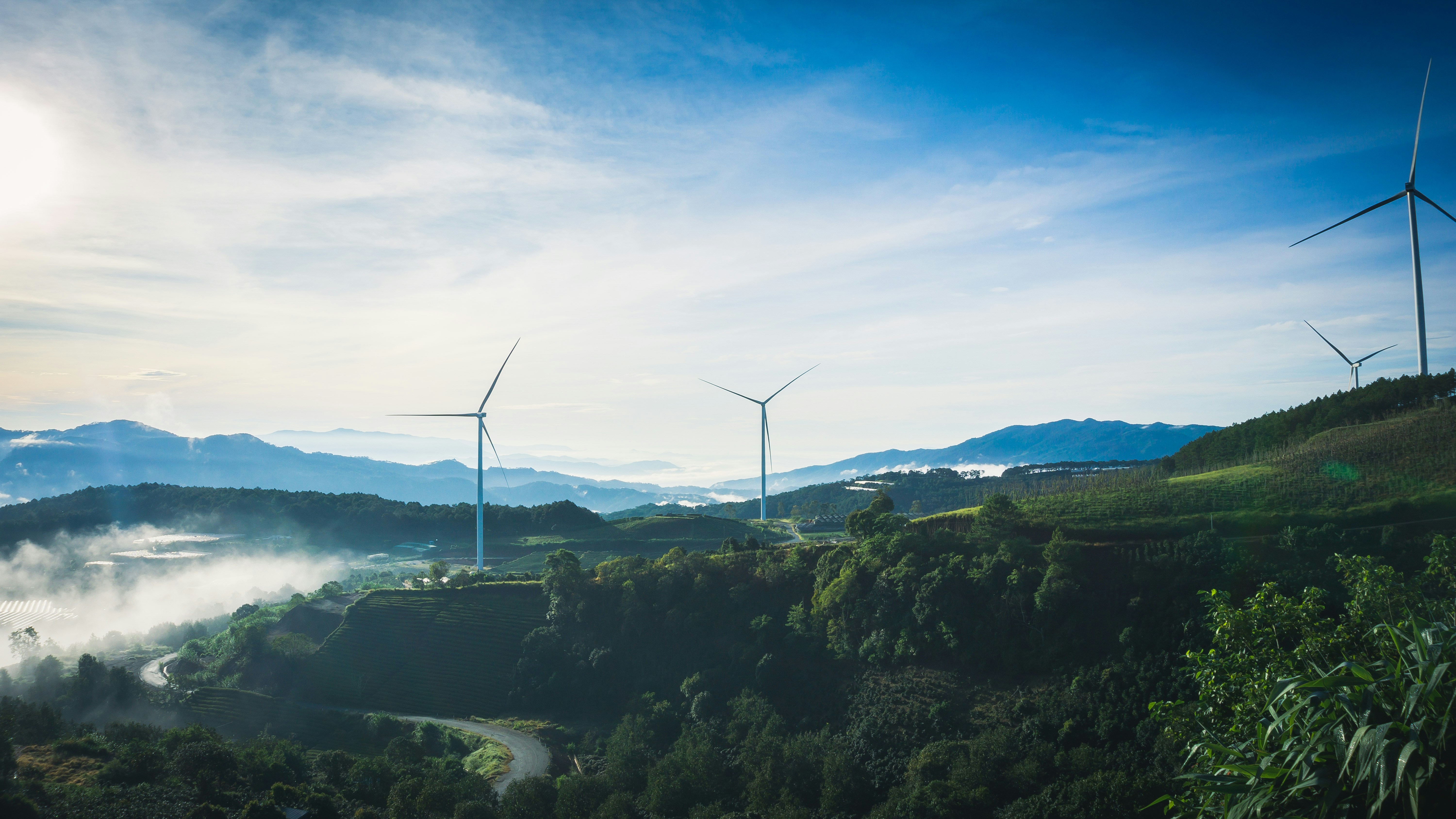 a group of wind turbines on a hill