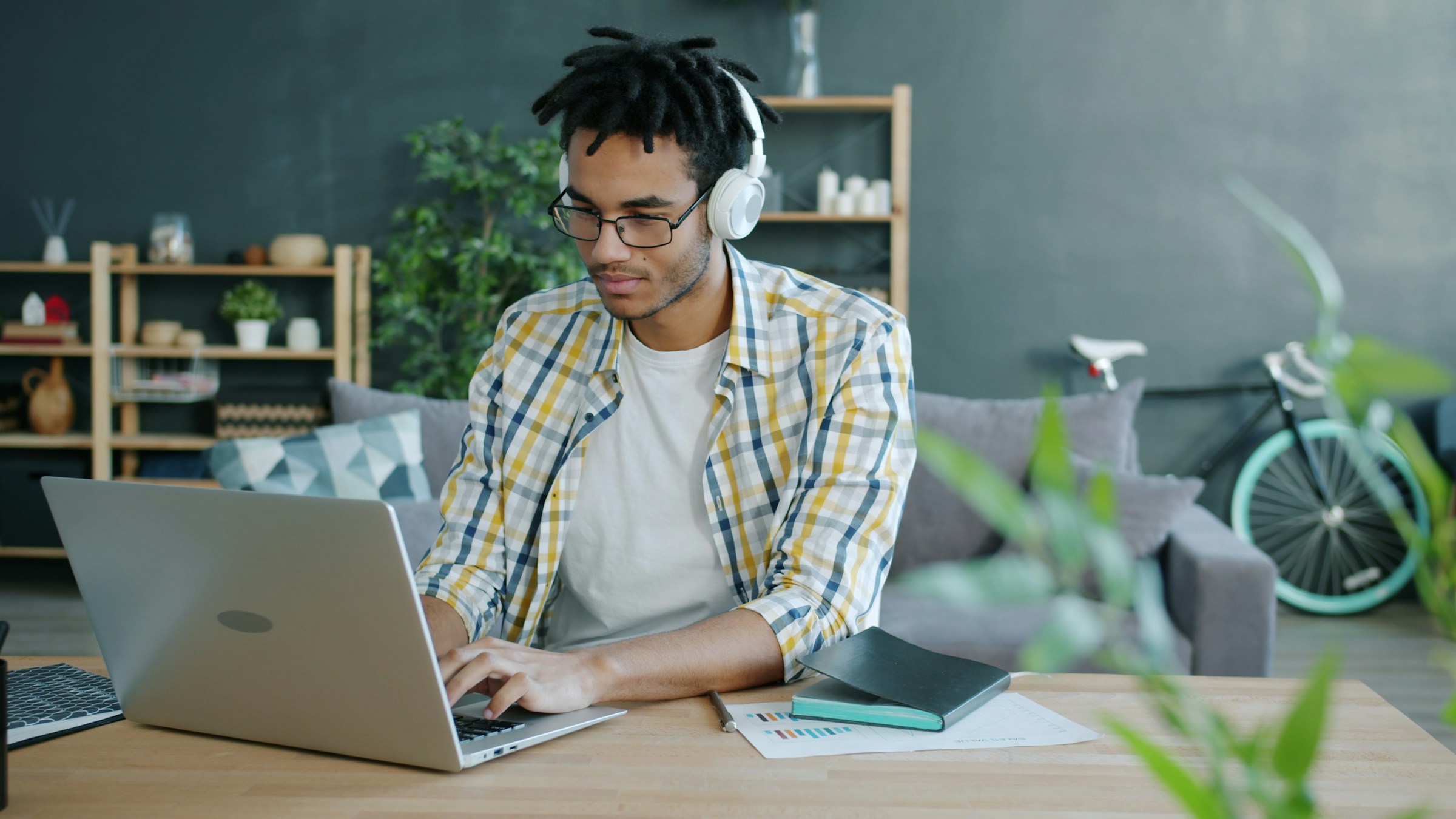 Man with headphones working on laptop at home office 