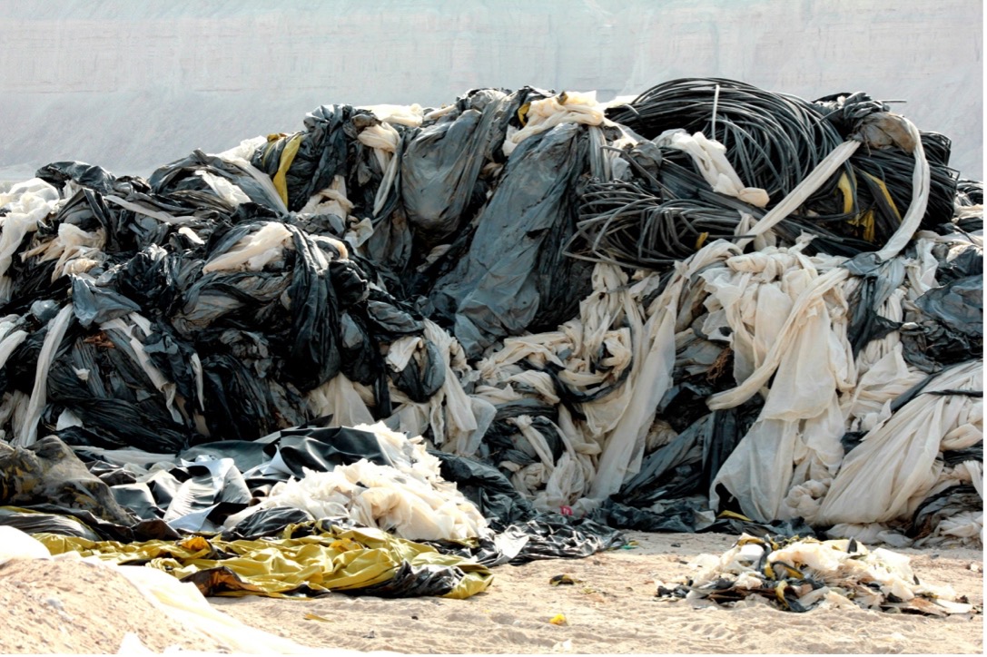 Outdoor landfill with trash and clothes gathered in piles