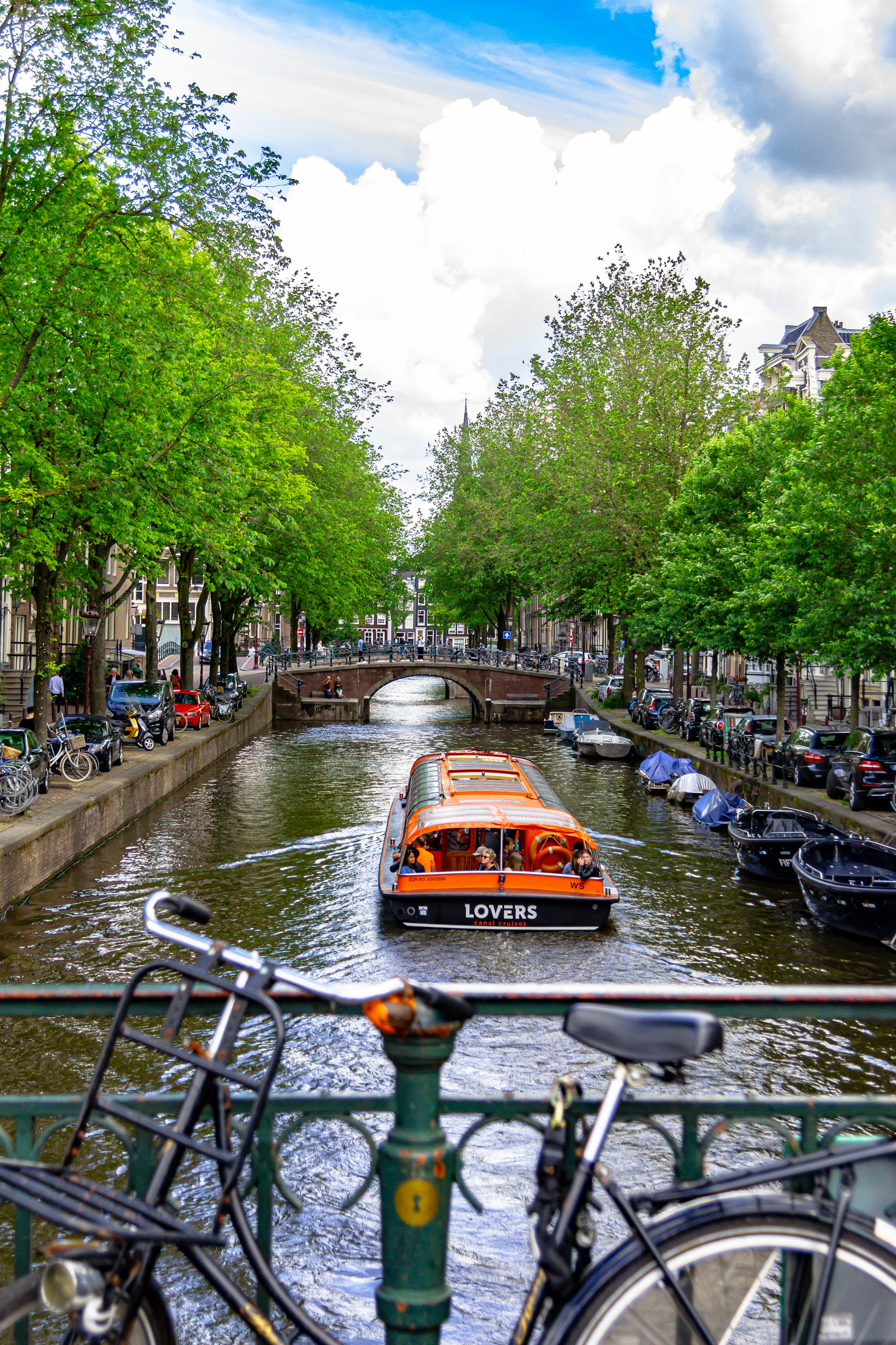 orange-boat-near-bridge-between-trees
