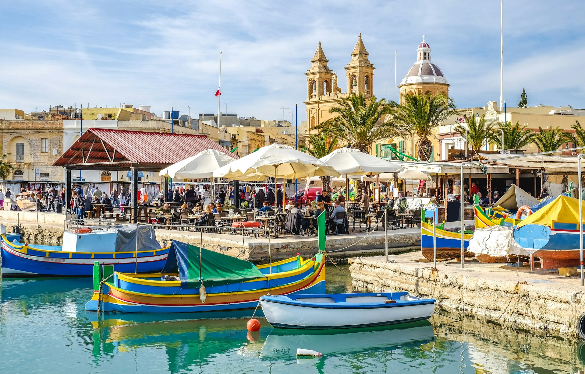blue-and-yellow-boat-on-water-near-brown-concrete-building-during-daytime
