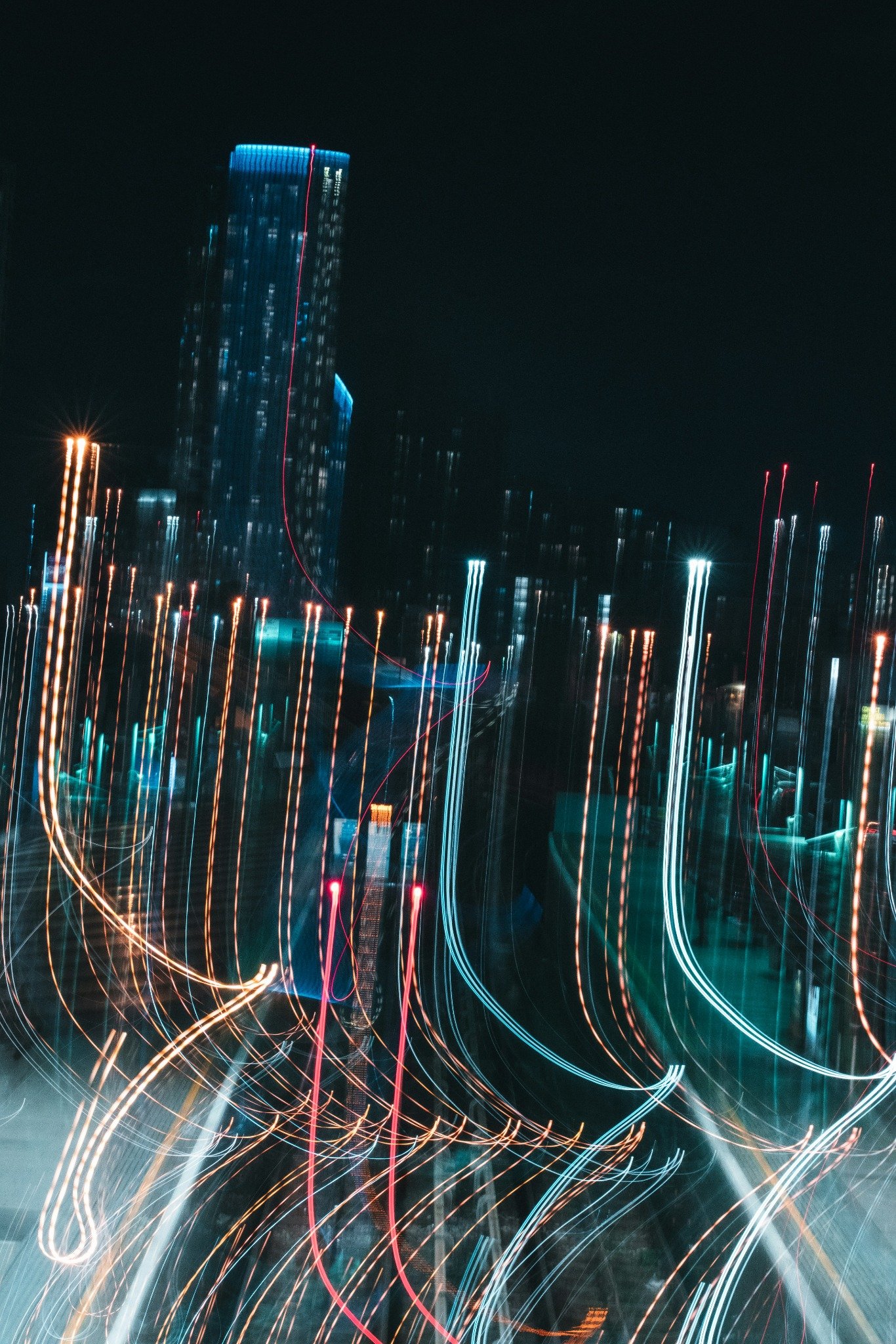 Blurred city lights at night with long exposure light trails representing digital data movement