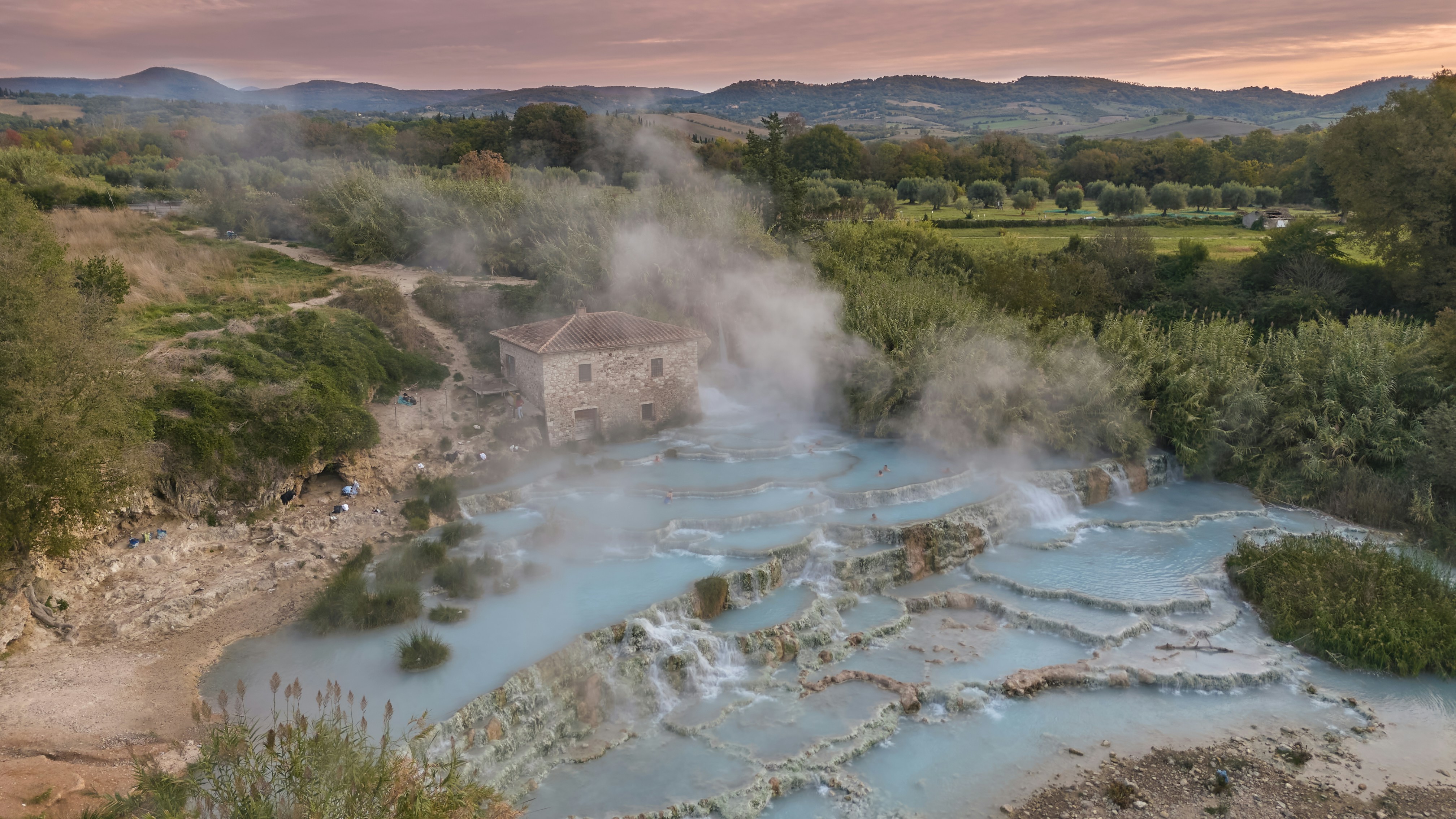 steaming-blue-thermal-springs-with-a-building-in-background