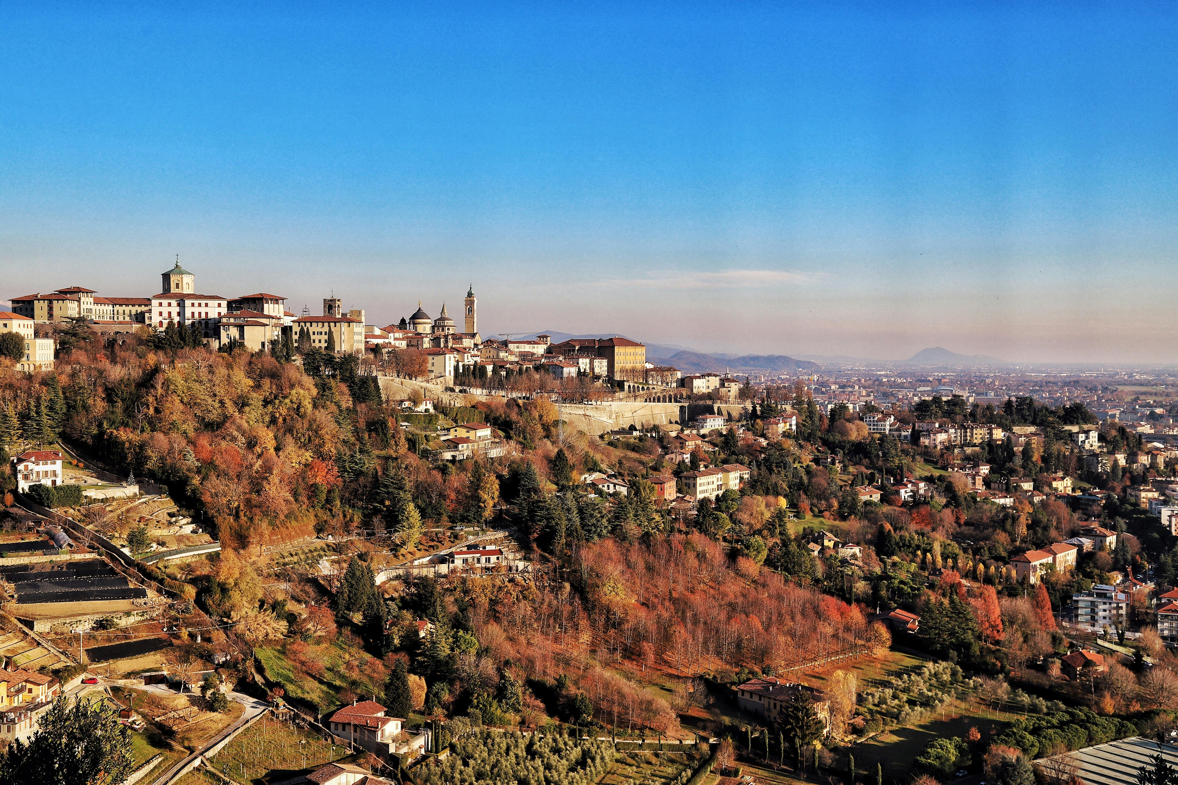 Hillside town with historic buildings and autumn scenery.