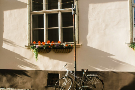 black-city-bike-parked-beside-white-concrete-wall