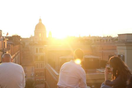 people-watch-sunset-over-city-buildings