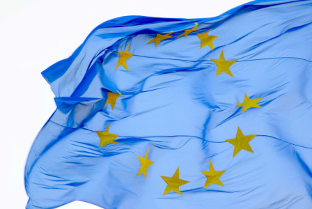EU flag with yellow stars forming circle waving. 
