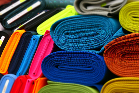 Colourful fabrics neatly rolled and displayed in a textile store.