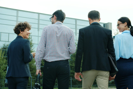 Business team walking outdoors by office building.