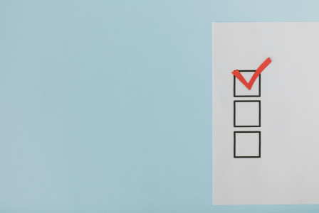 A minimalist checklist with a red checkmark on a blue background.