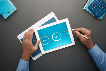 A professional reviewing statistical data on a tablet.