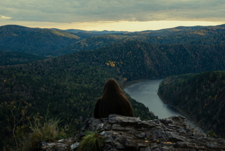 person-overlooking-vast-forest-and-river-valley