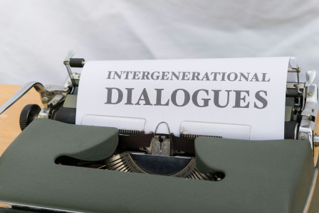 Colour photograph of the black text “intergenerational dialogues” on a white piece of paper on a typewriter. Markus Winkler on unsplash.