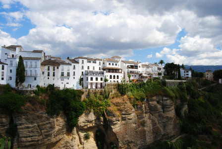 white-concrete-building-on-brown-rocky-mountain-under-white-clouds-and-blue-sky-during-daytime