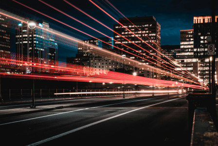 A picture presents a city street at night with light trails.