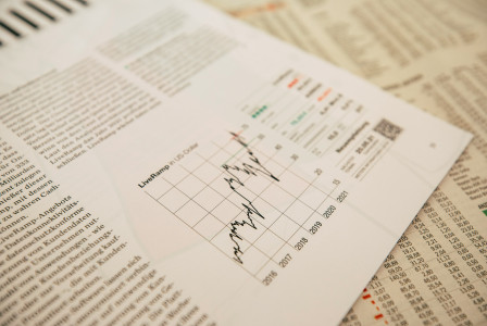 Financial newspaper clipping with stock chart.