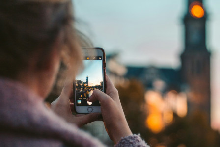 A picture presents a person taking a photo of a city landmark.