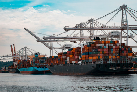 The photo presents container ships at a busy port.